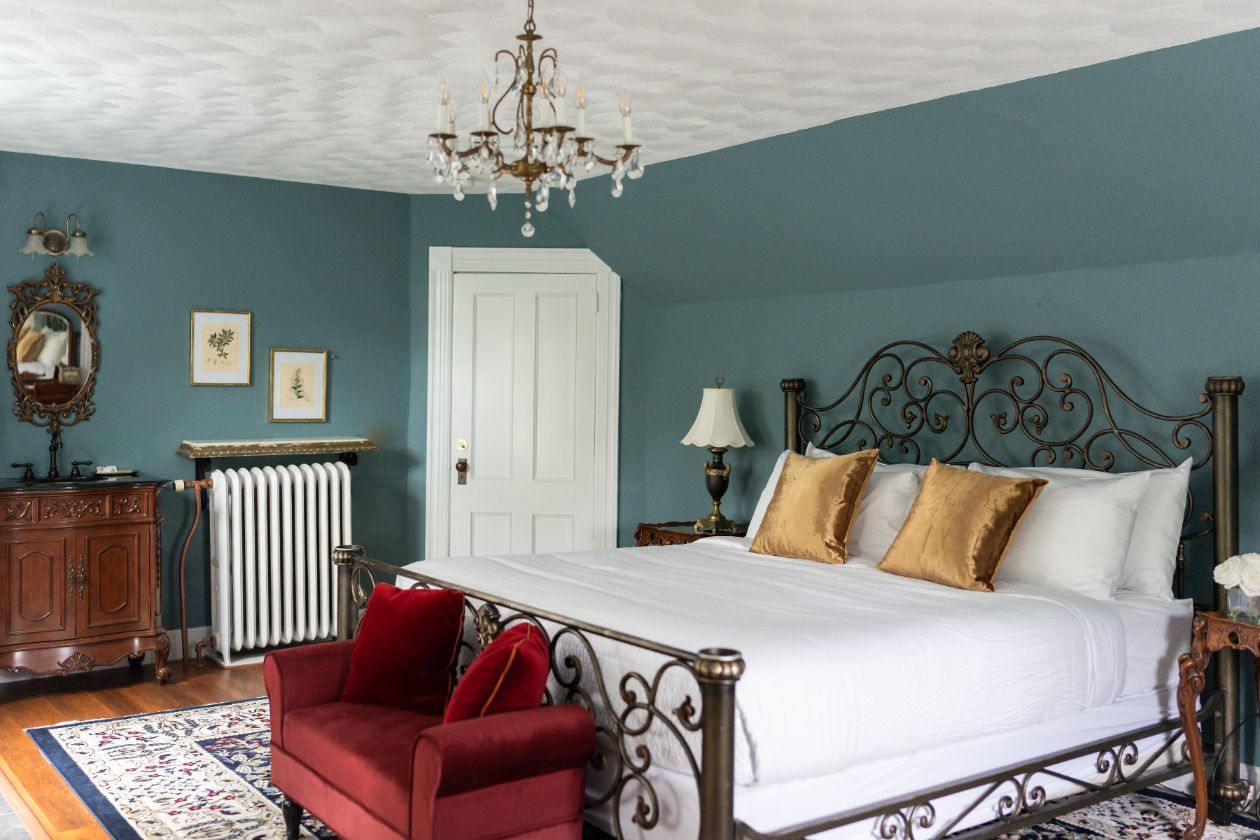 A bedroom with a king size bed and a red chair