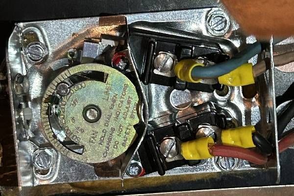 An open furnace fan limit control switch with colored wires connected to screw terminals inside a metal electrical box.