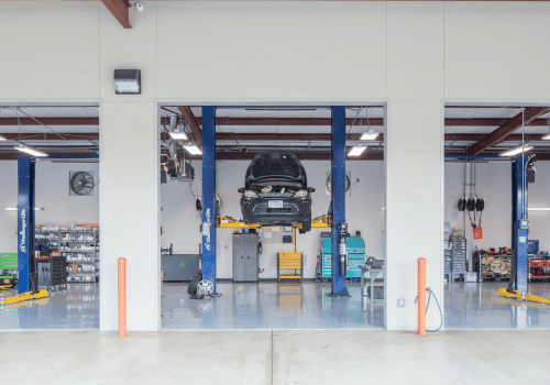 Total True Automotive service bay with a car lifted on a hoist