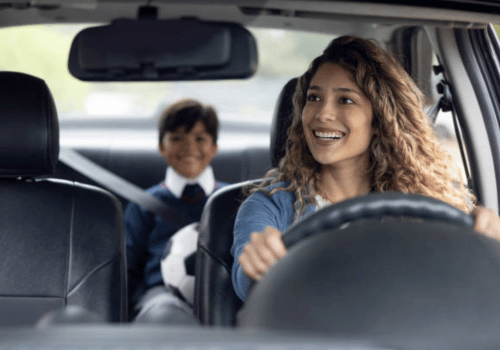 Smiling parent and child in car, seen from the front seats