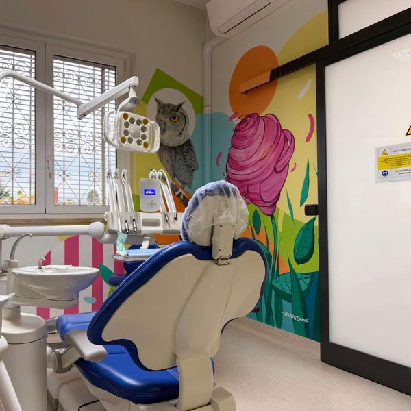 Luminoso studio dentistico pediatrico con un murale colorato e una poltrona odontoiatrica vuota
