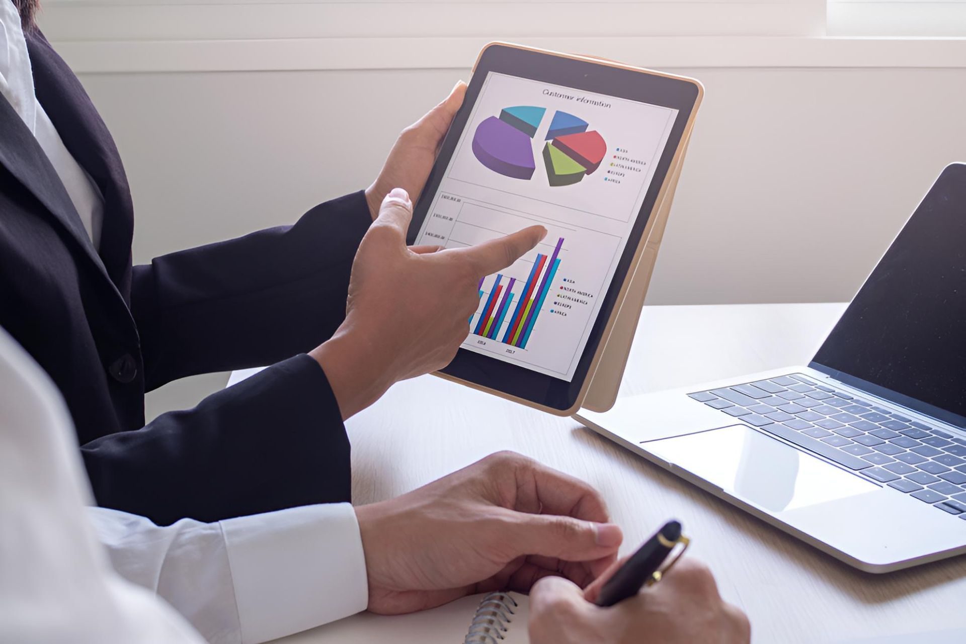 Two People Are Looking at a Tablet With a Pie Chart on It — Darling Downs Bookkeeping Company in Gatton, QLD