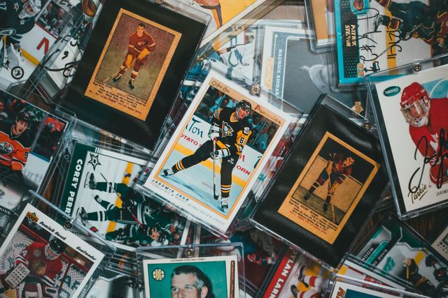 Scattered vintage trading cards in plastic sleeves on a tabletop, with colorful illustrated portraits.