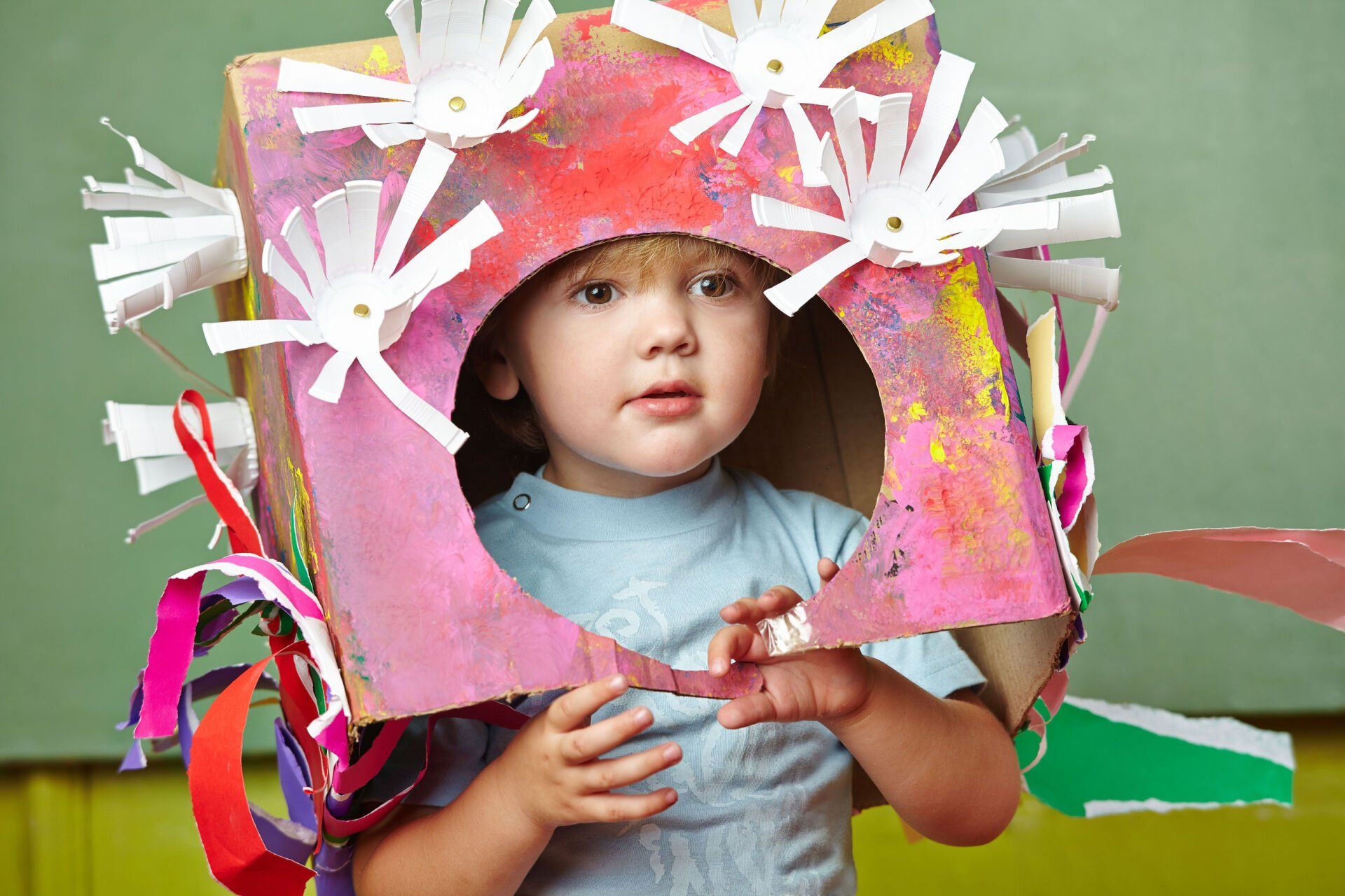 Child wearing a colorful cardboard box 
