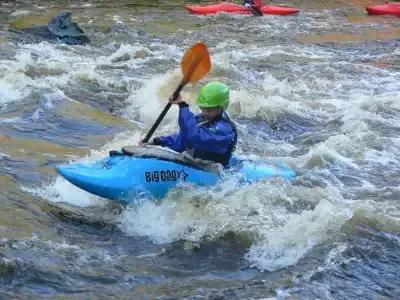 A person in a blue kayak with the word big on it