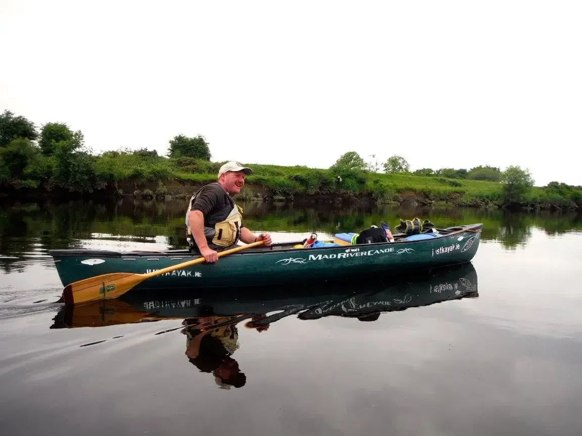 Paddle Northern Ireland | A man is rowing a canoe on a river.