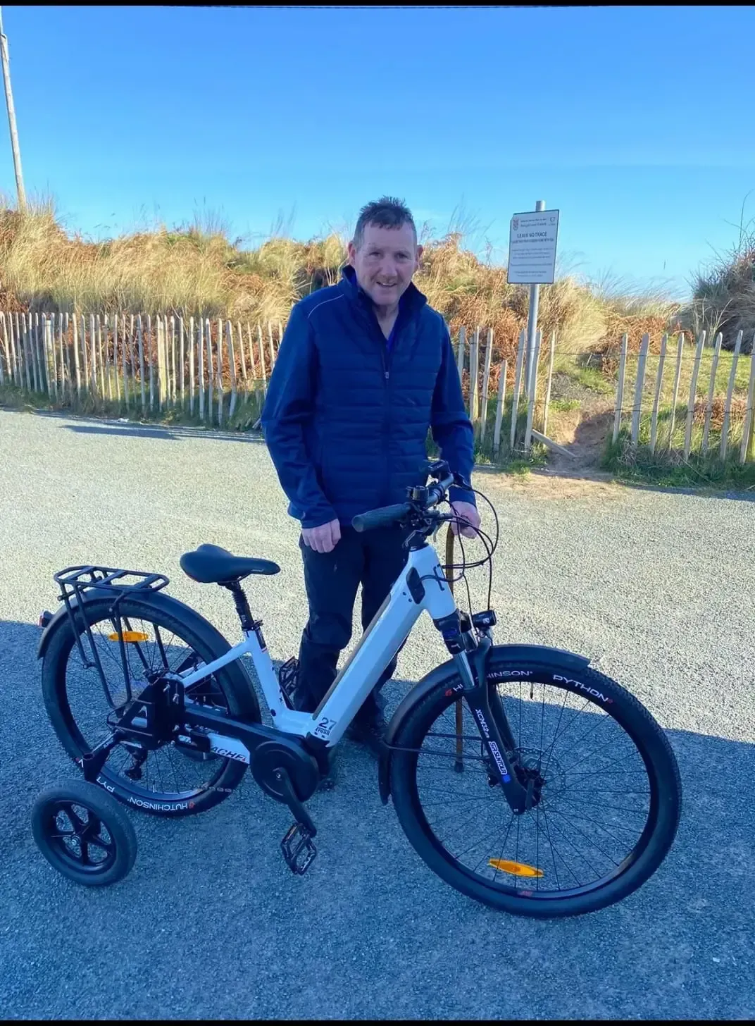 A man is standing next to an electric bike