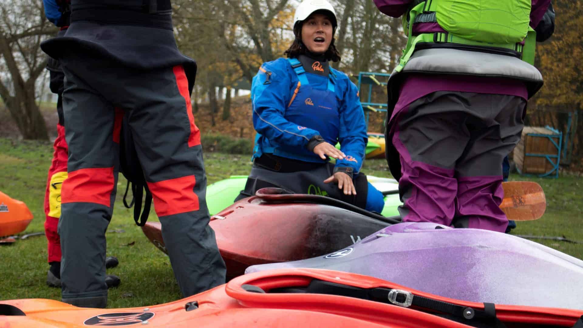 A man in a red vest is paddling a kayak on a lake