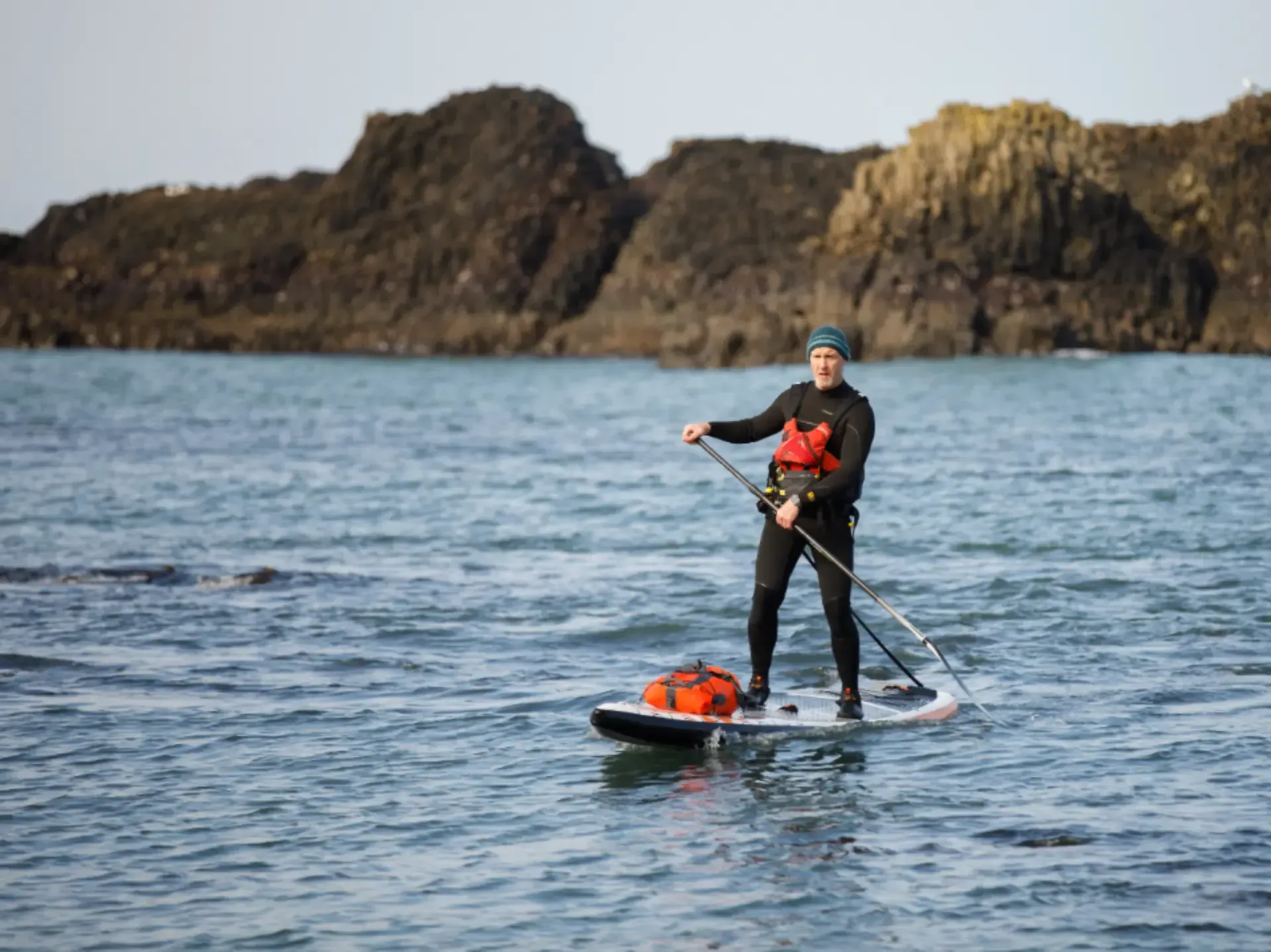 A man is paddling a kayak down a river.