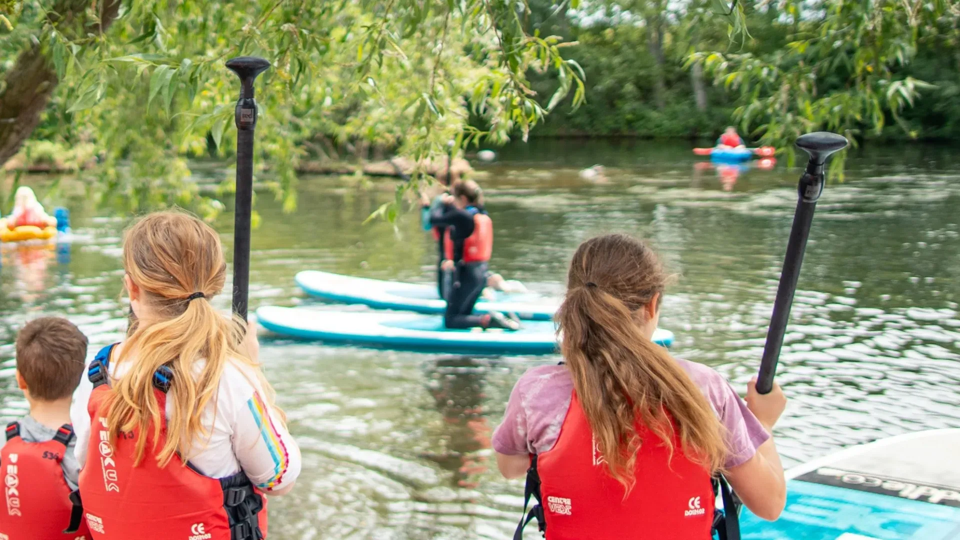 Paddle Northern Ireland | A group of people are standing on paddle boards in the water.