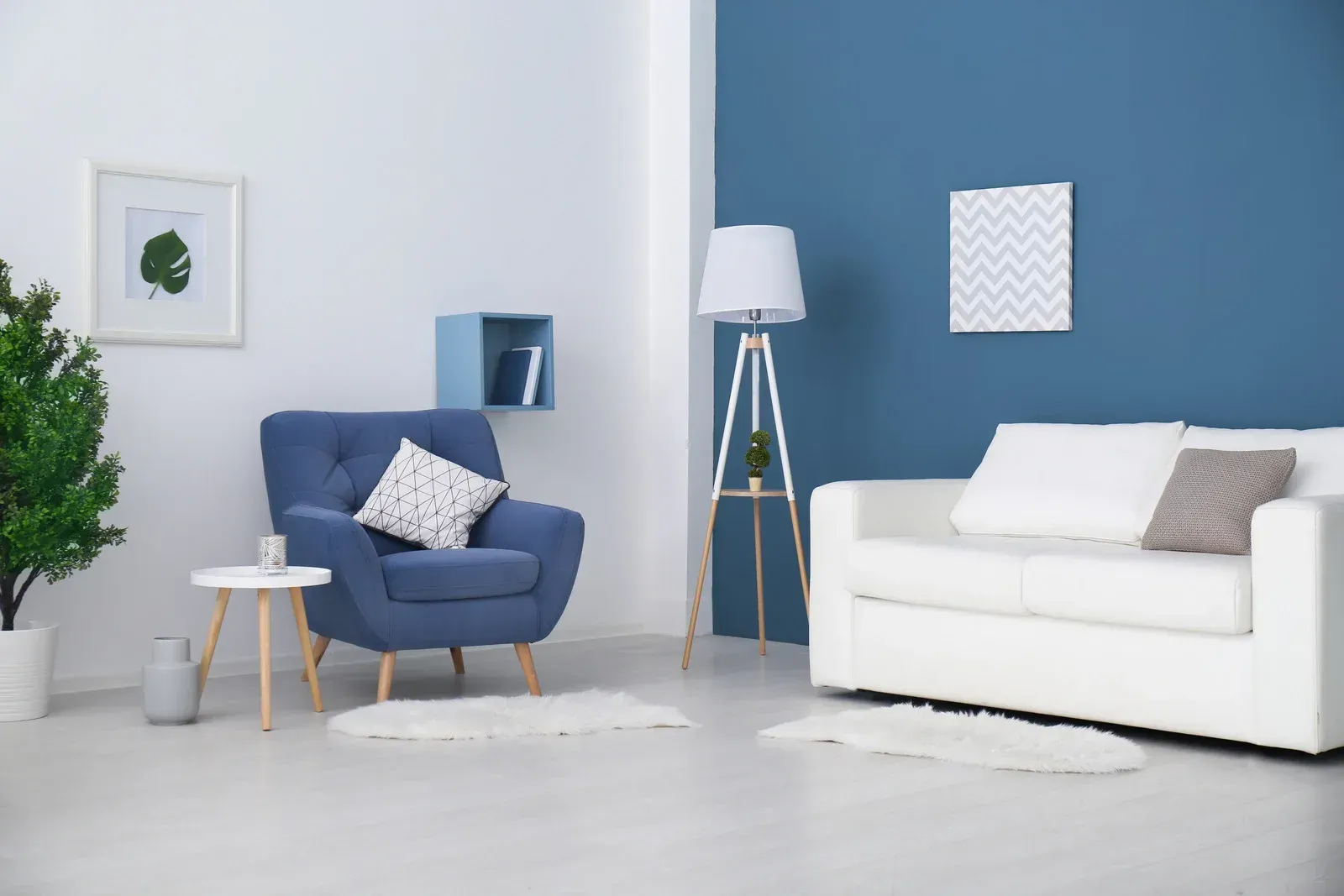 Living room with blue accent wall, white sofa, blue armchair, and a floor lamp.