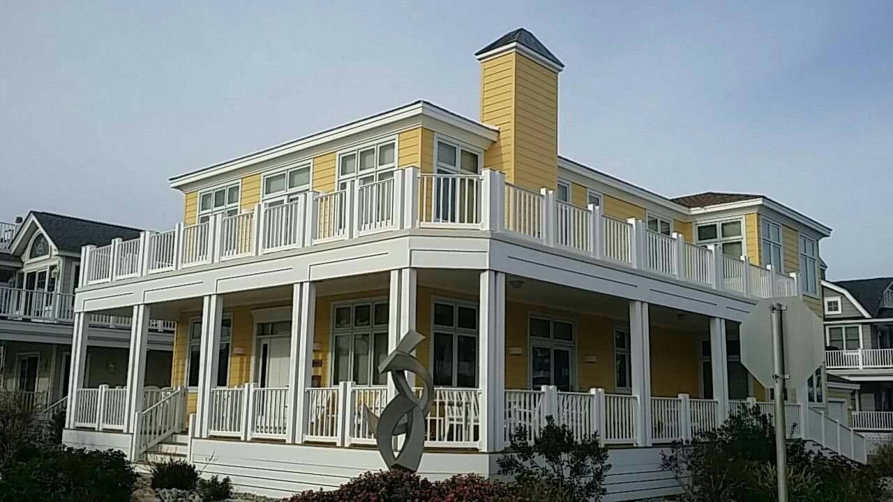 A Large Yellow and White House With a Large Porch