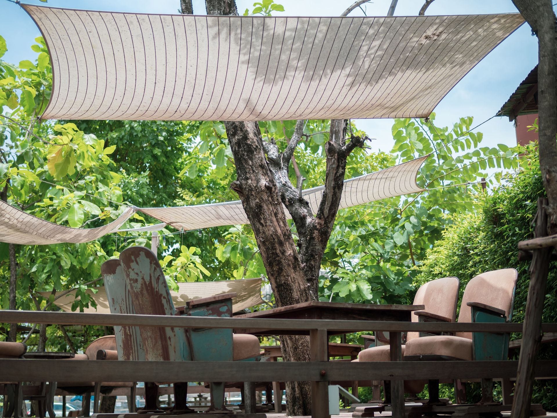 A patio with tables and chairs under a shade sail | Cordova & Pasadena, MD | Shoreline Awning & Trim
