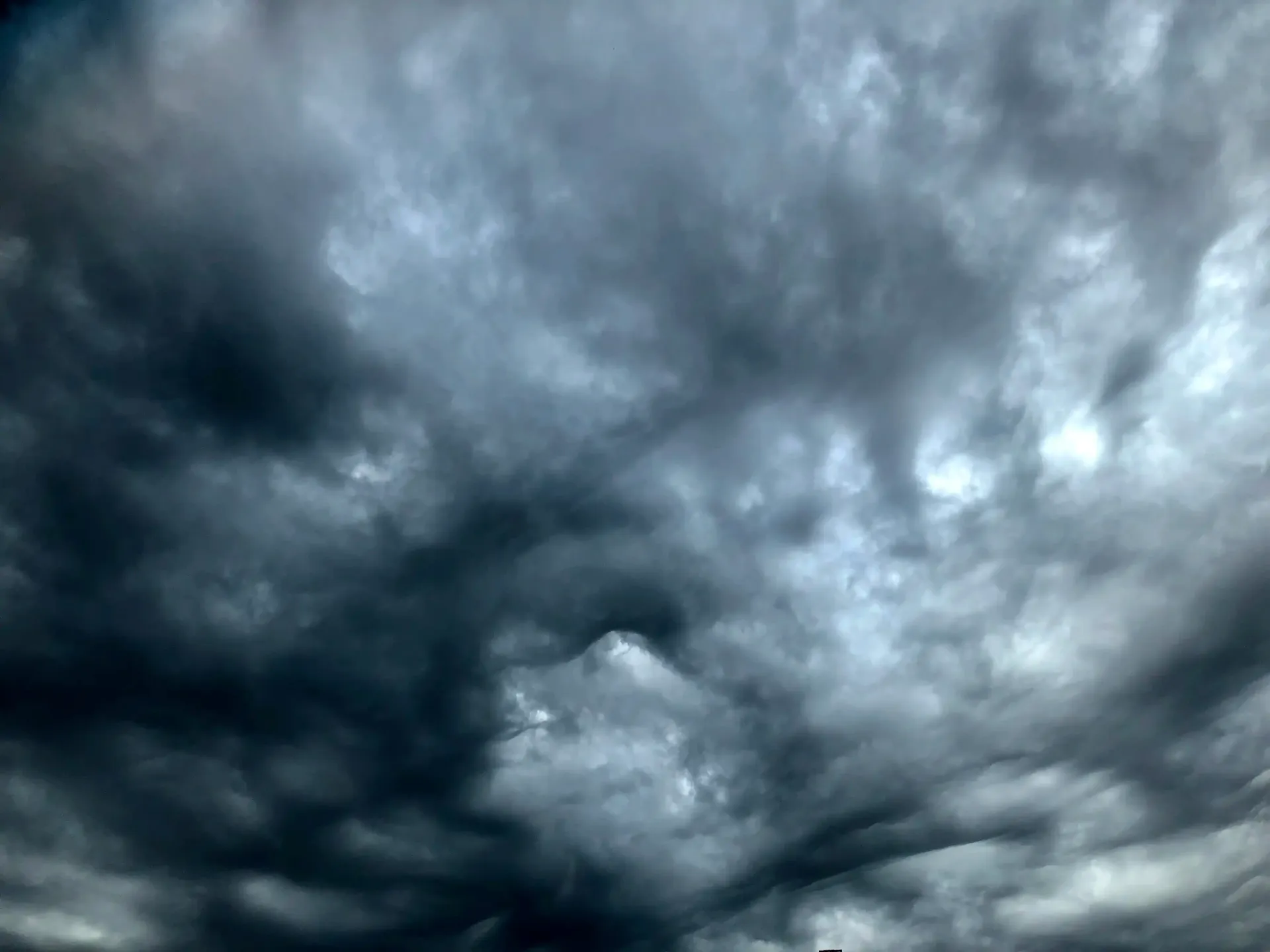 un cielo nuvoloso scuro con qualche nuvola bianca al suo interno