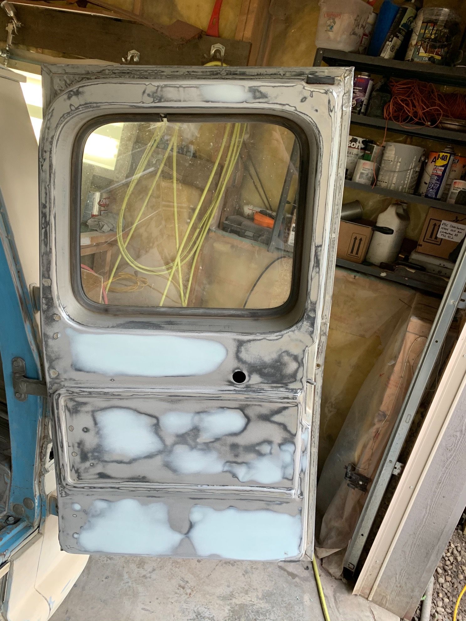 A door with a window is sitting in a garage.
