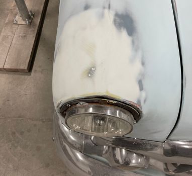 A close up of a car 's headlight and fender.