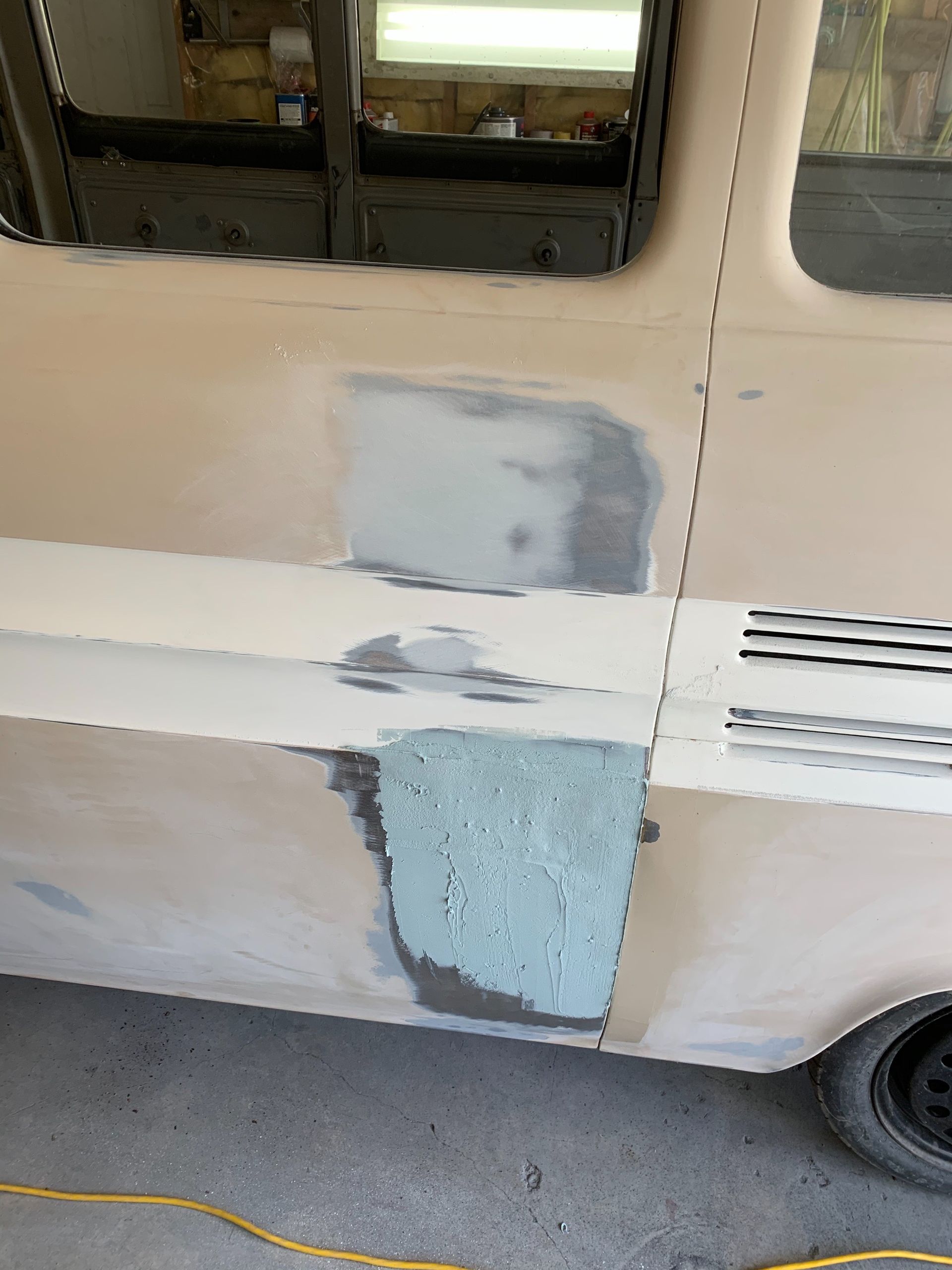 A white van is being painted in a garage.