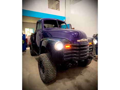A purple truck is parked in a garage.