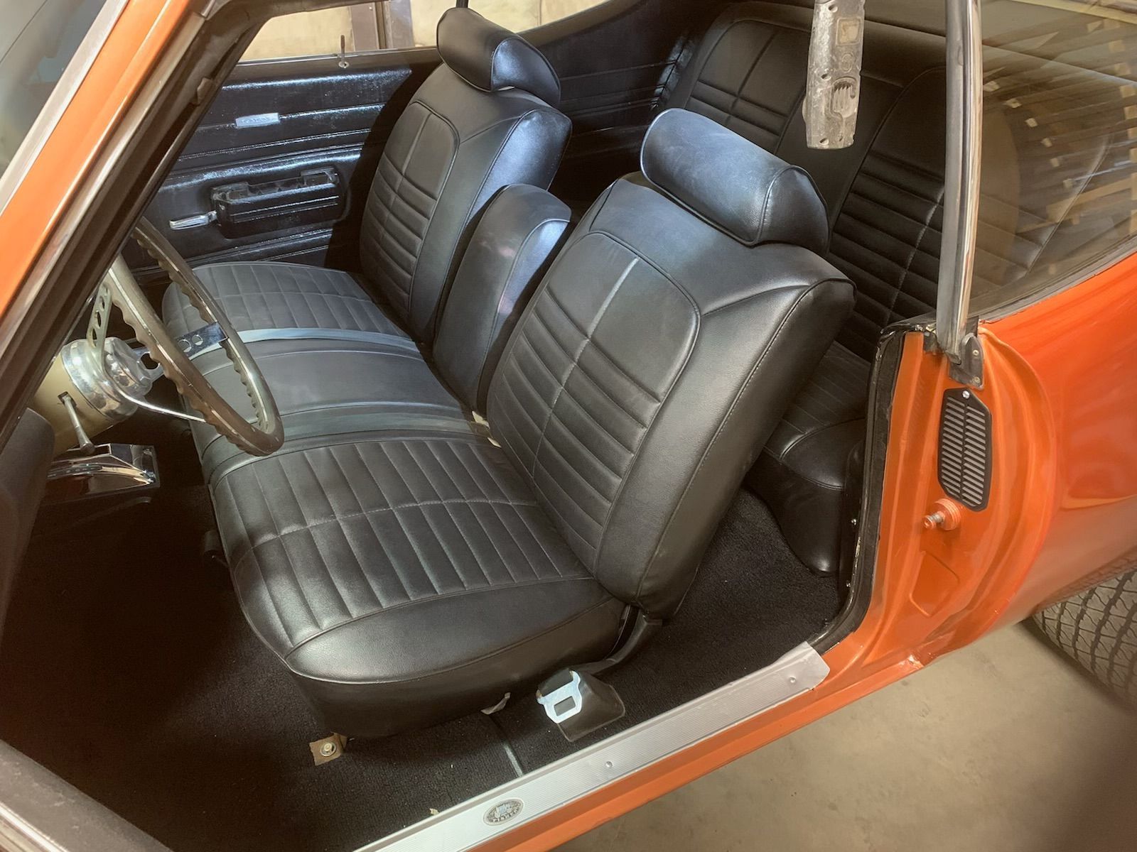 An orange car with black seats and a steering wheel