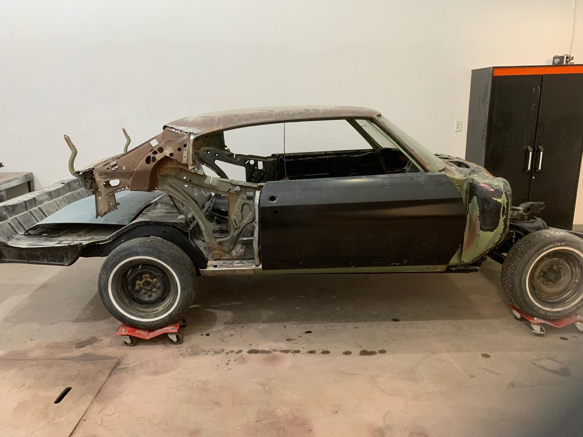 A car is sitting on wheels in a garage.