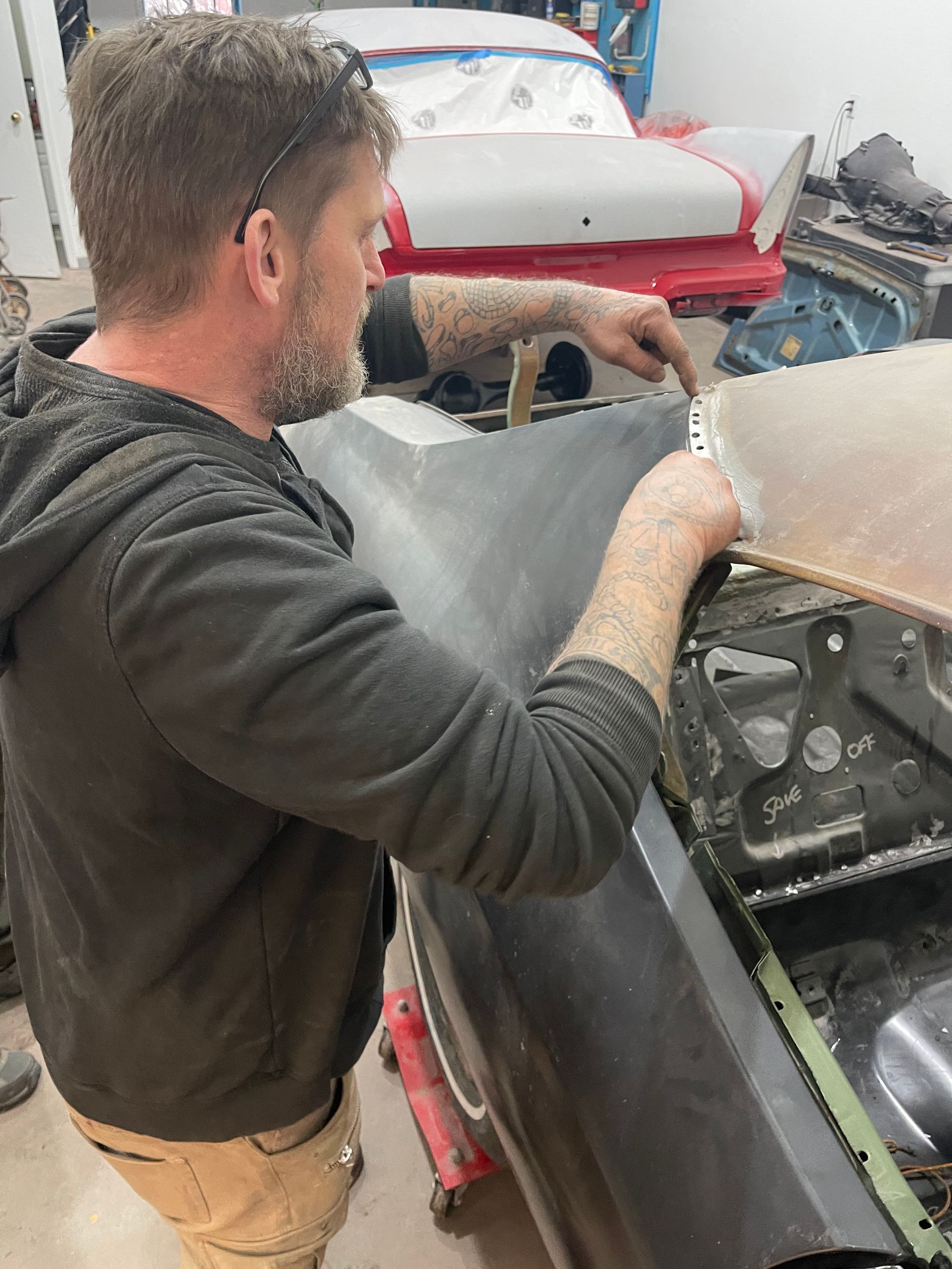A man is working on a car in a garage.