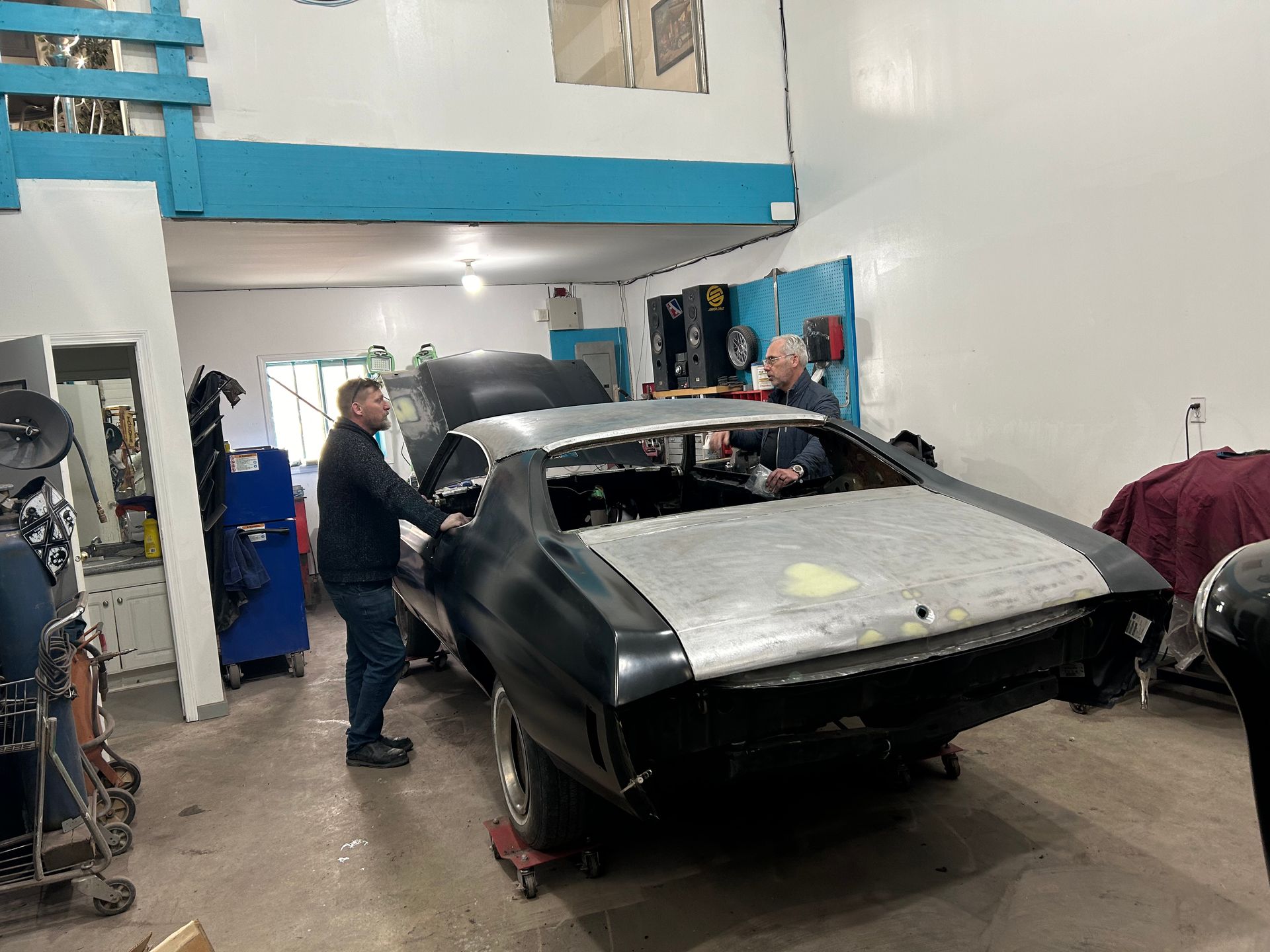 A man is working on a car in a garage.