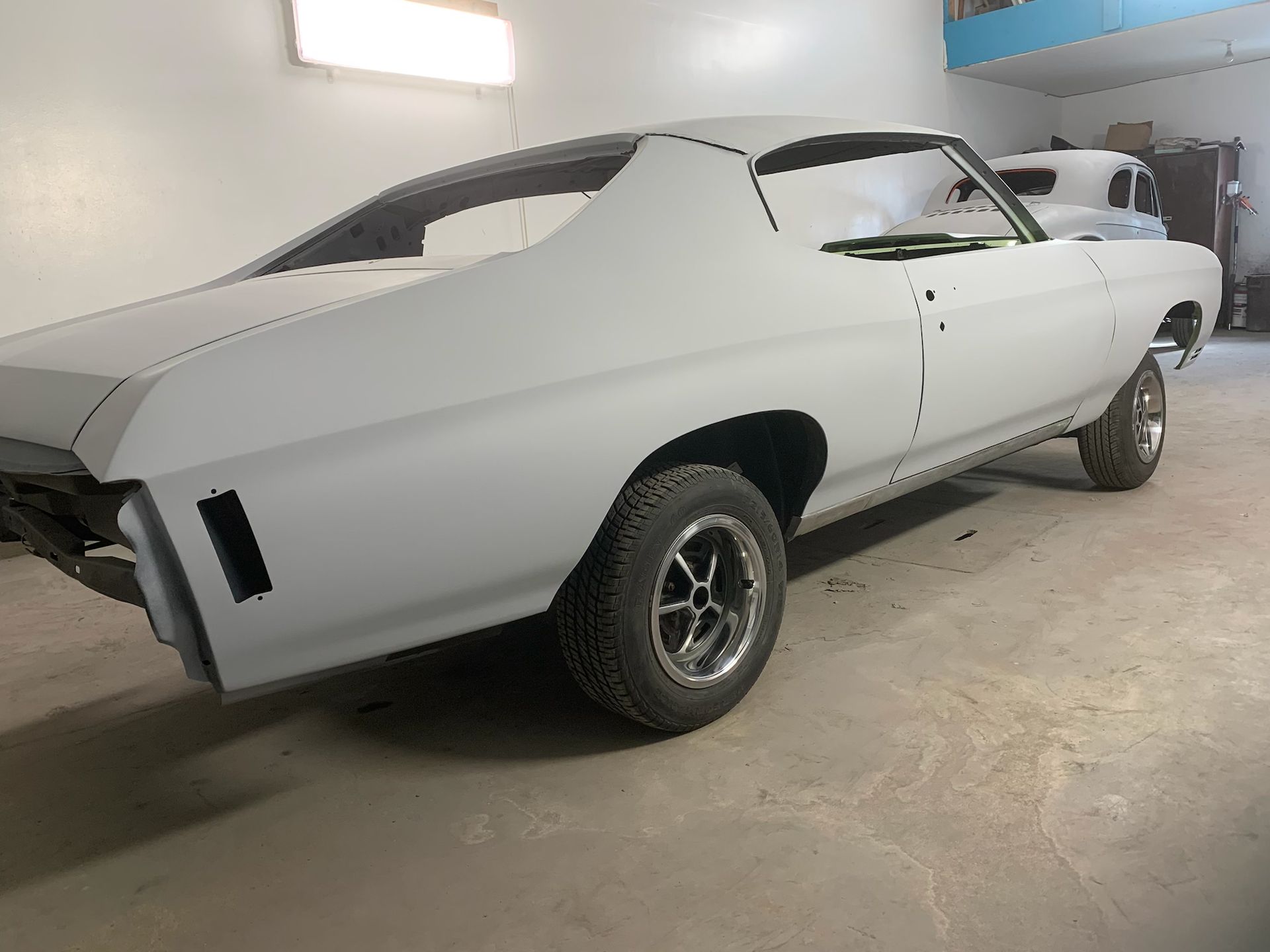 A white car is parked in a garage.