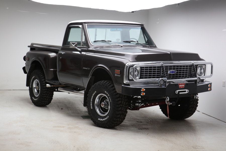 A black pickup truck is parked in a showroom.