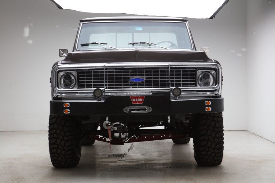 A black chevrolet truck is parked in a garage.