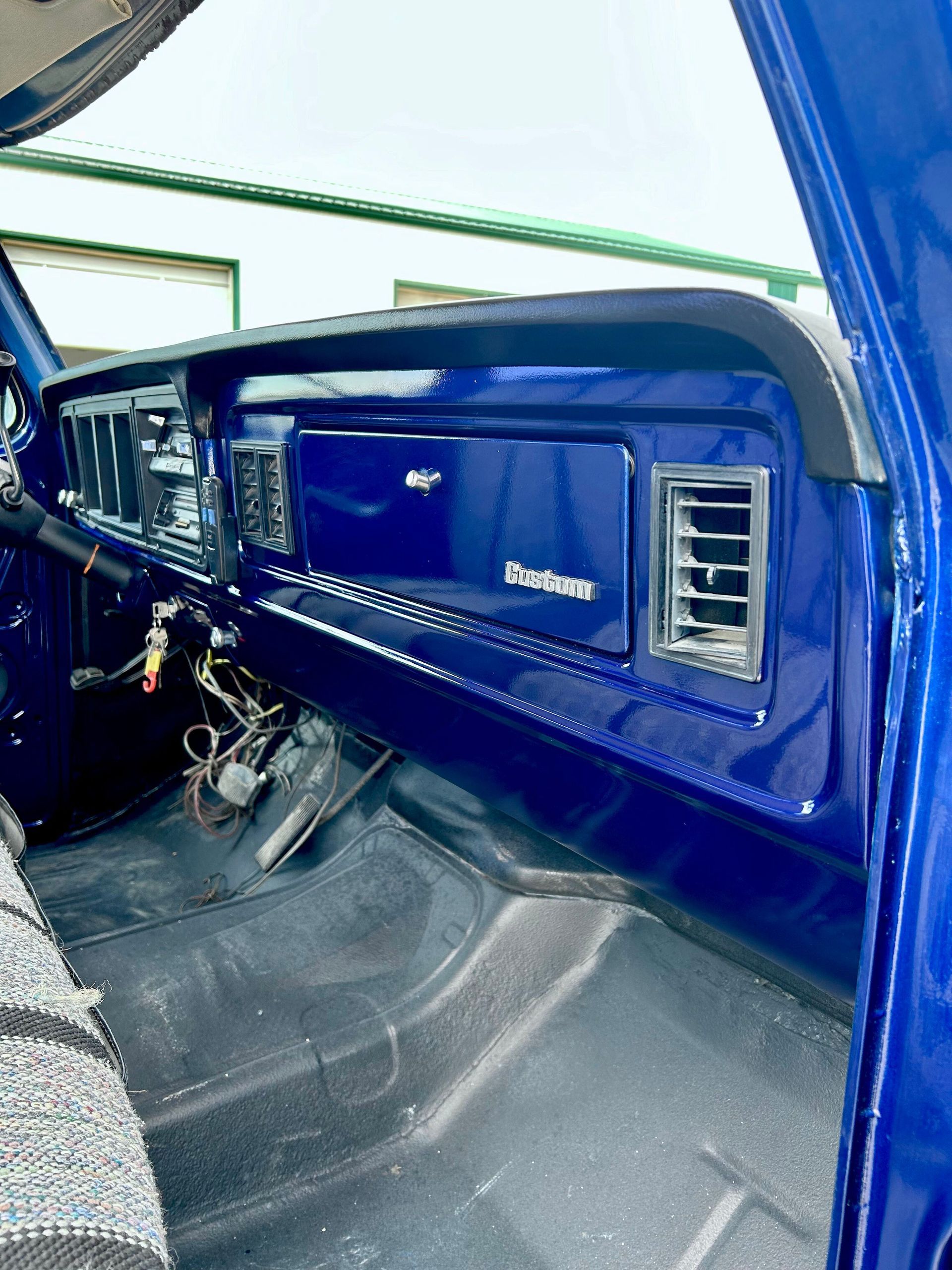 Blue classic car dashboard and front interior with chrome vents and steering wheel view