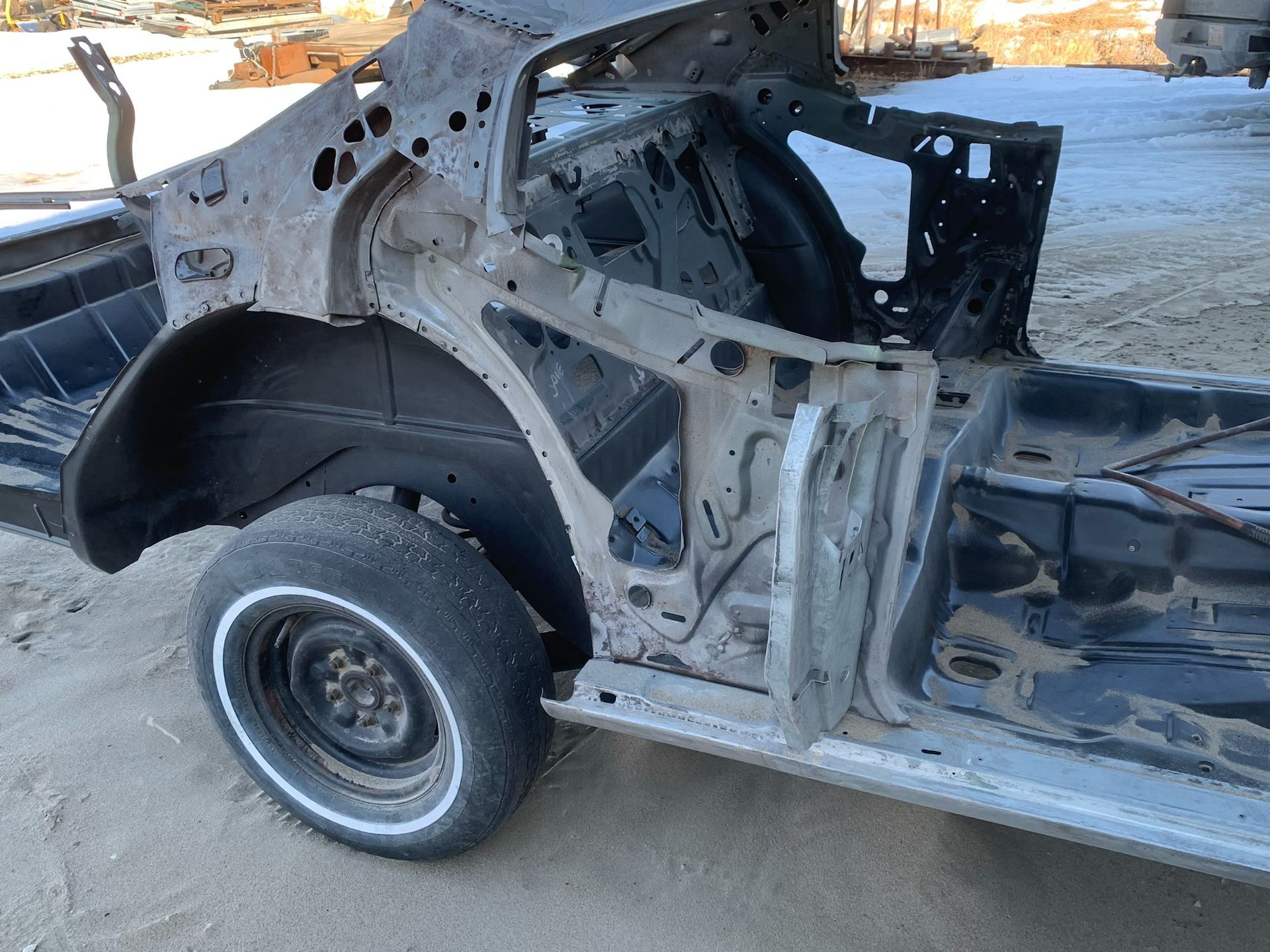 A car that has been cut in half is sitting on the ground