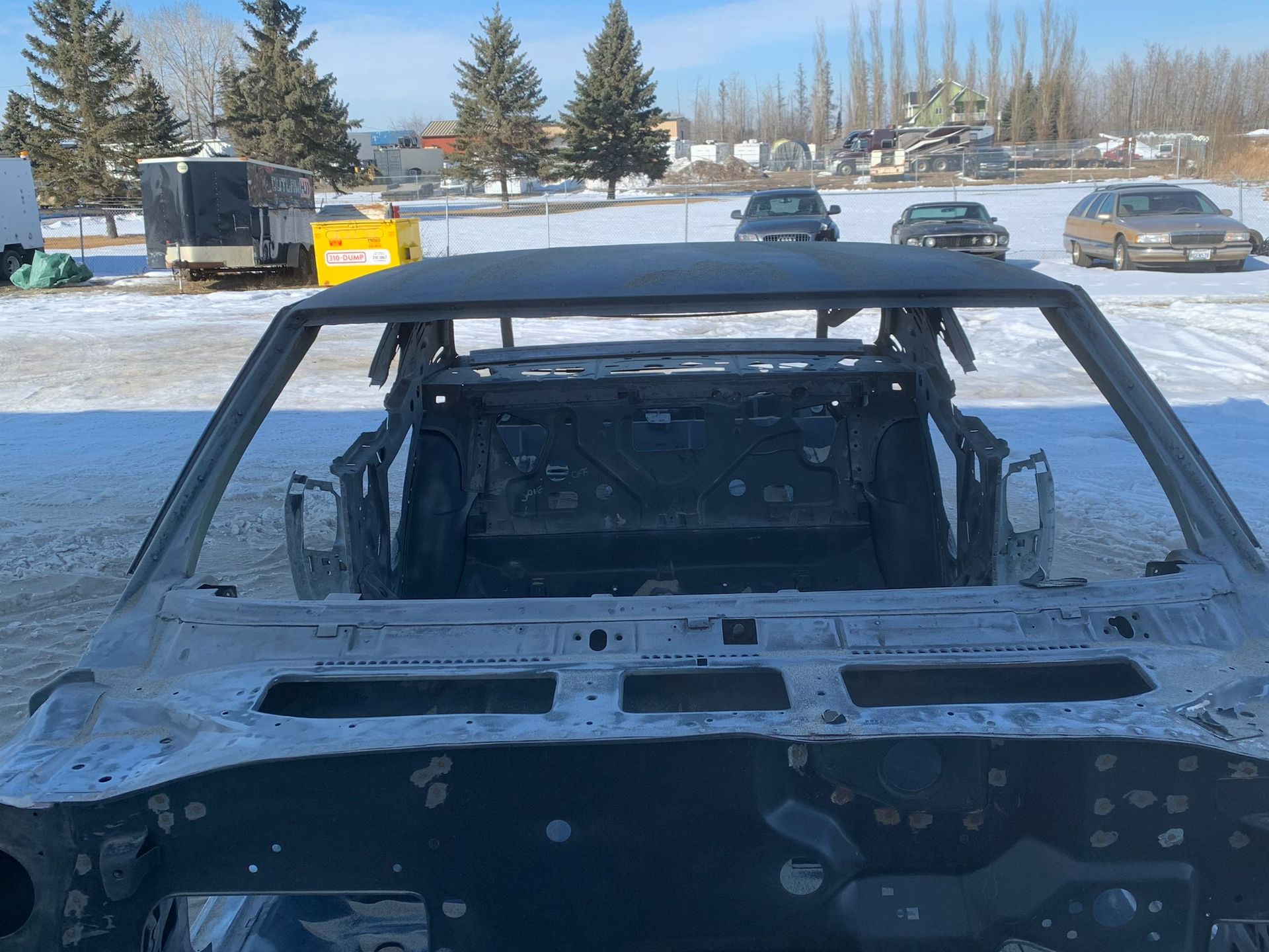 A car is sitting in the snow in a parking lot.