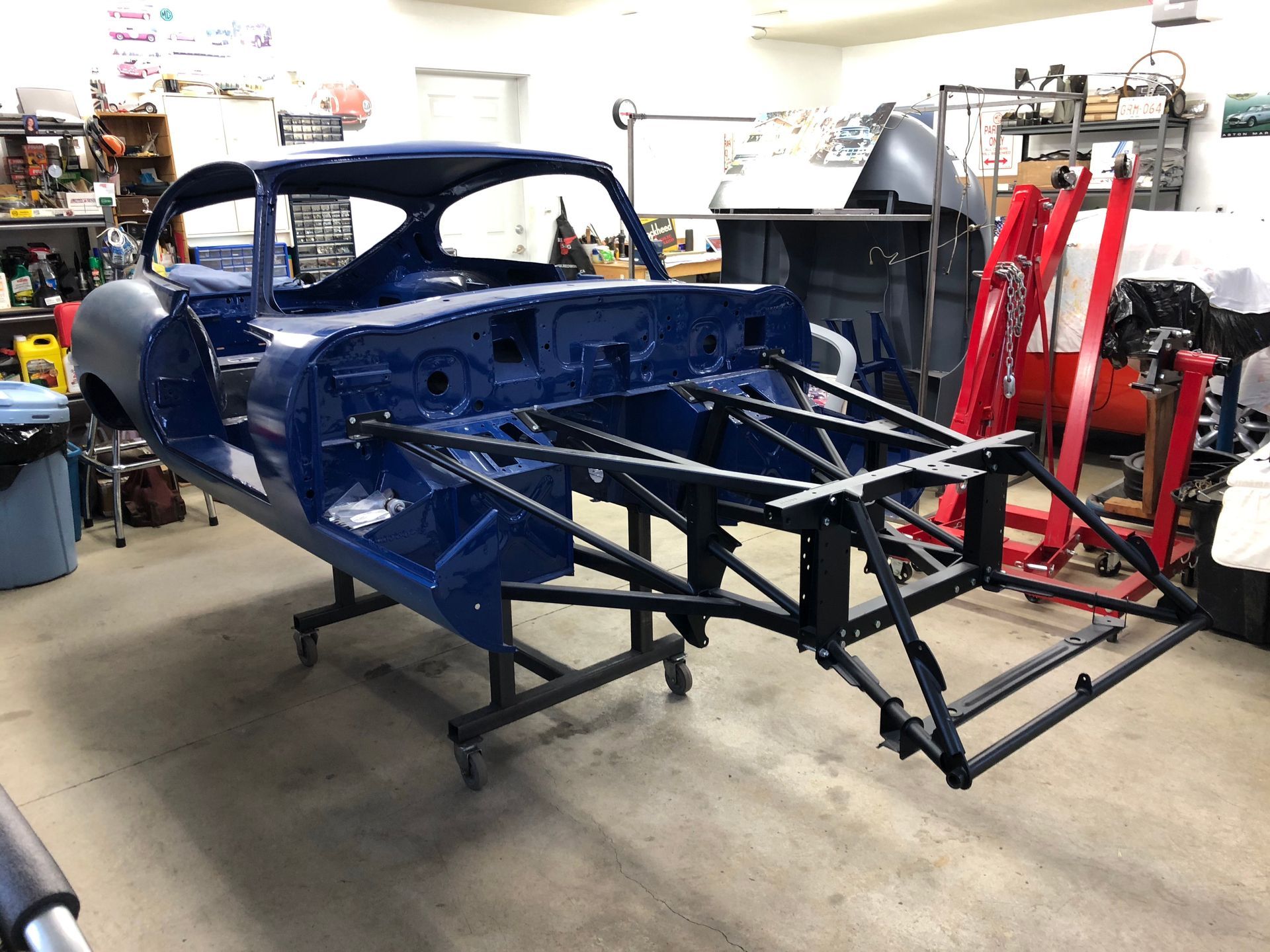 A blue car is sitting on top of a metal frame in a garage.