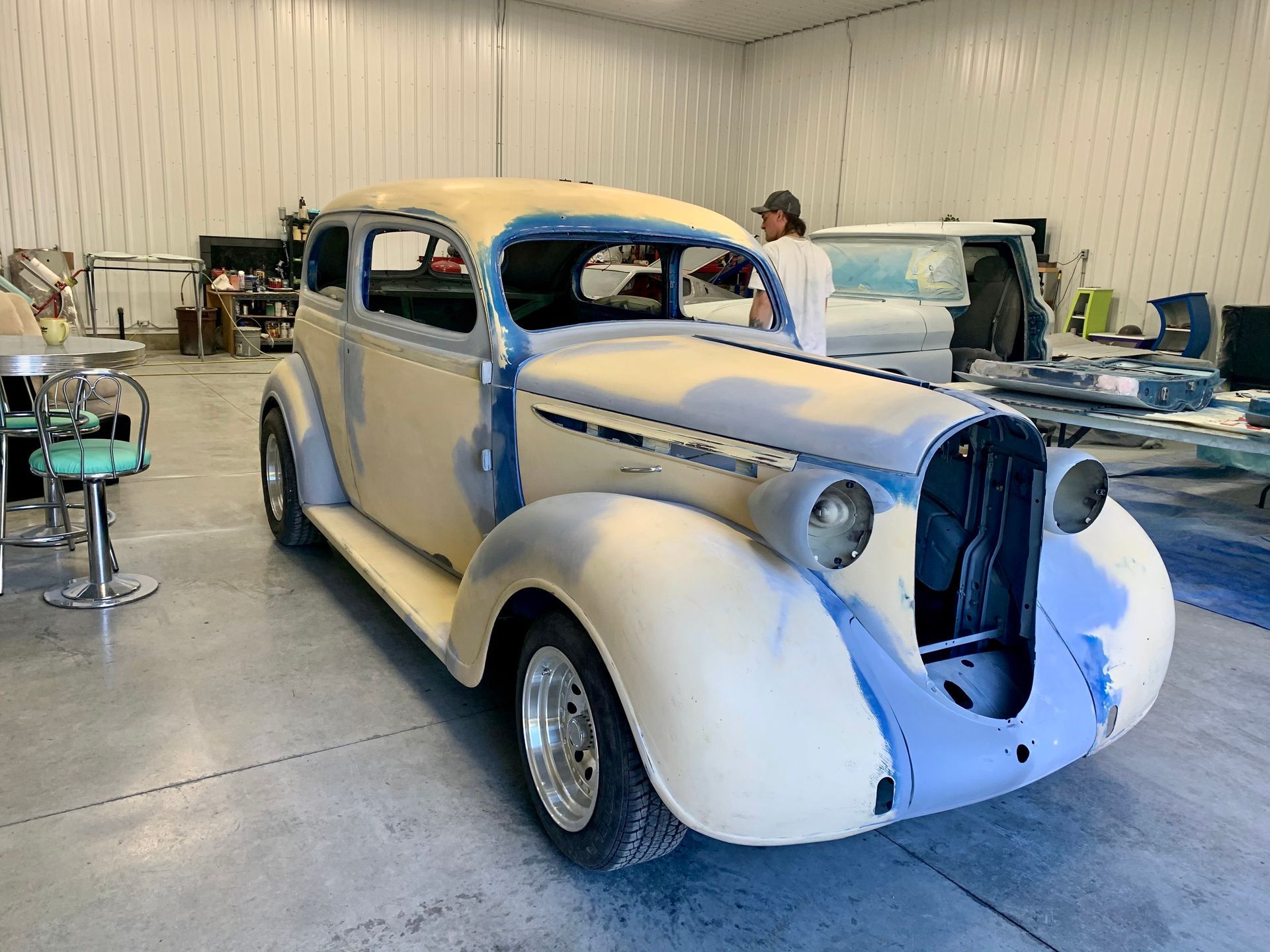 An old car is being restored in a garage.
