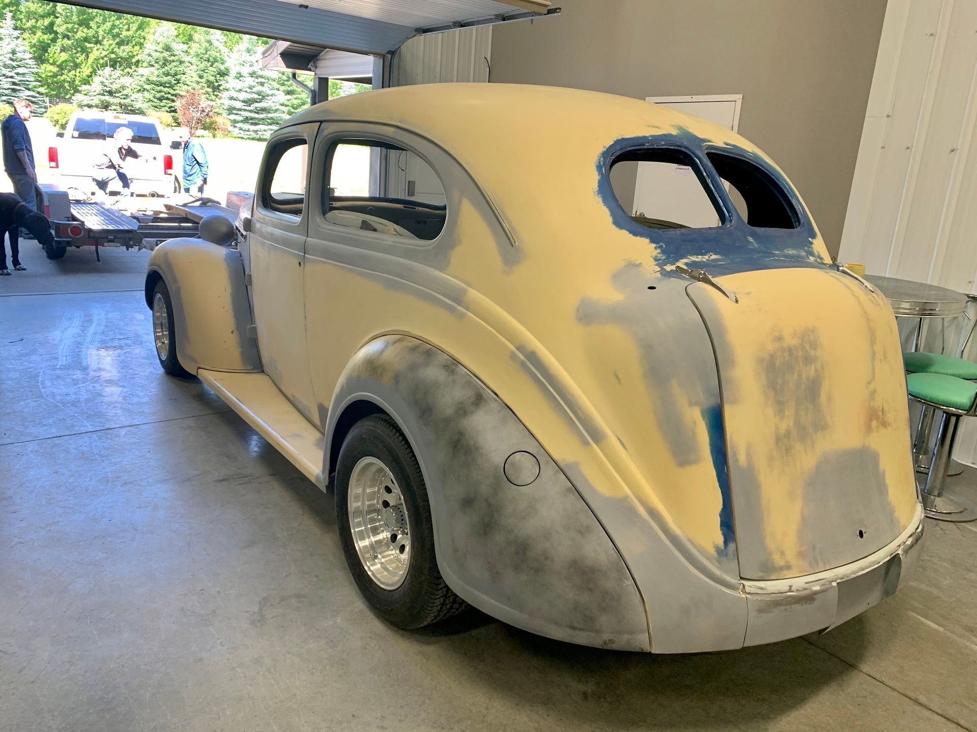 An old car is being painted in a garage