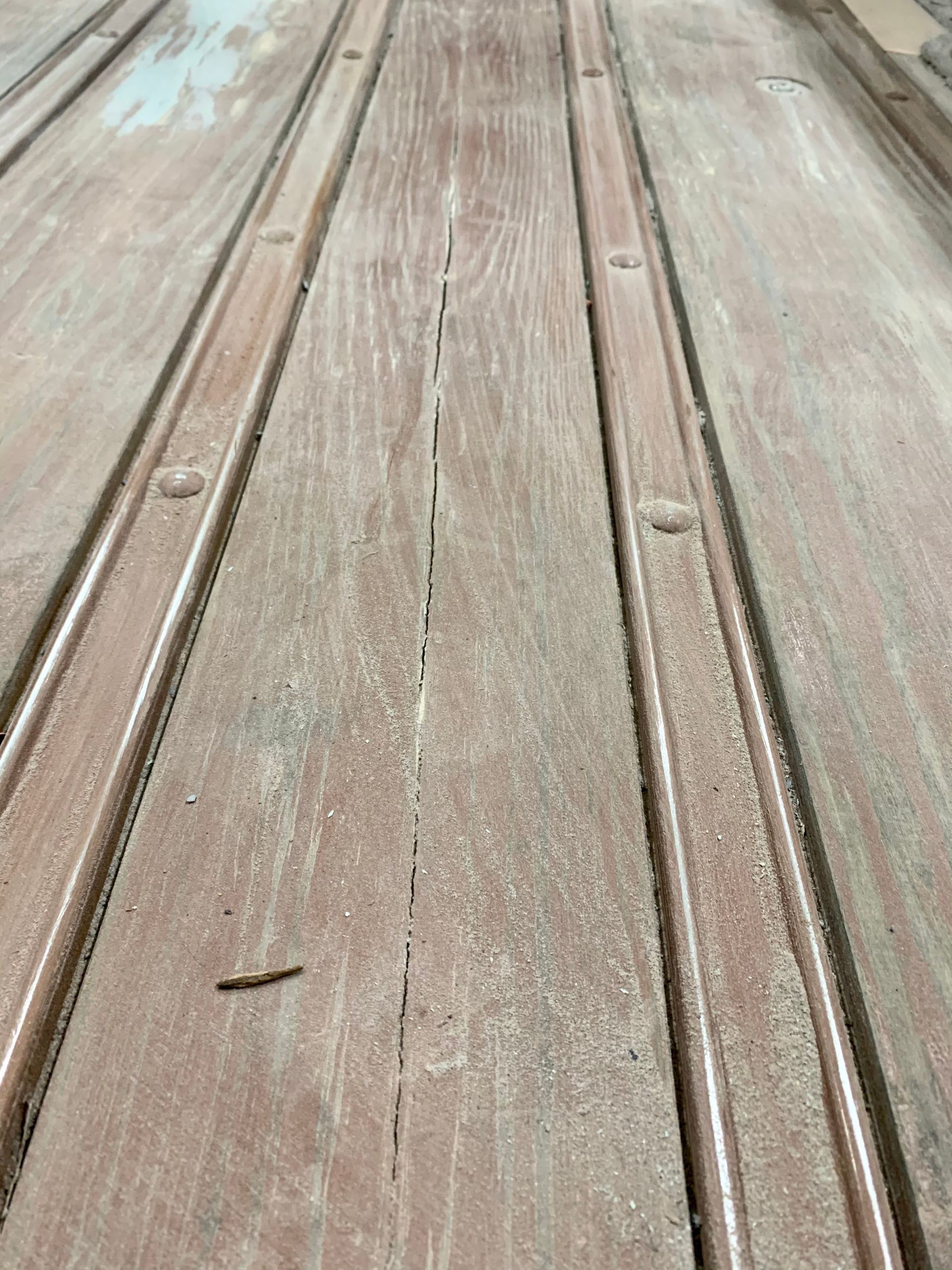 A close up of a wooden deck with a few holes in it