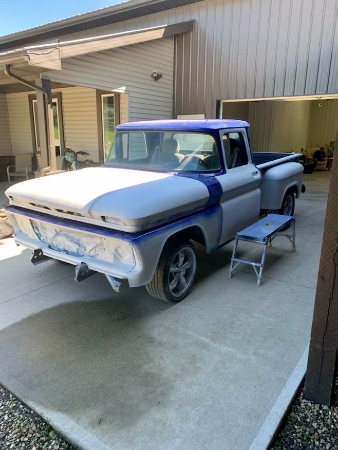 A truck is parked in a driveway in front of a building.
