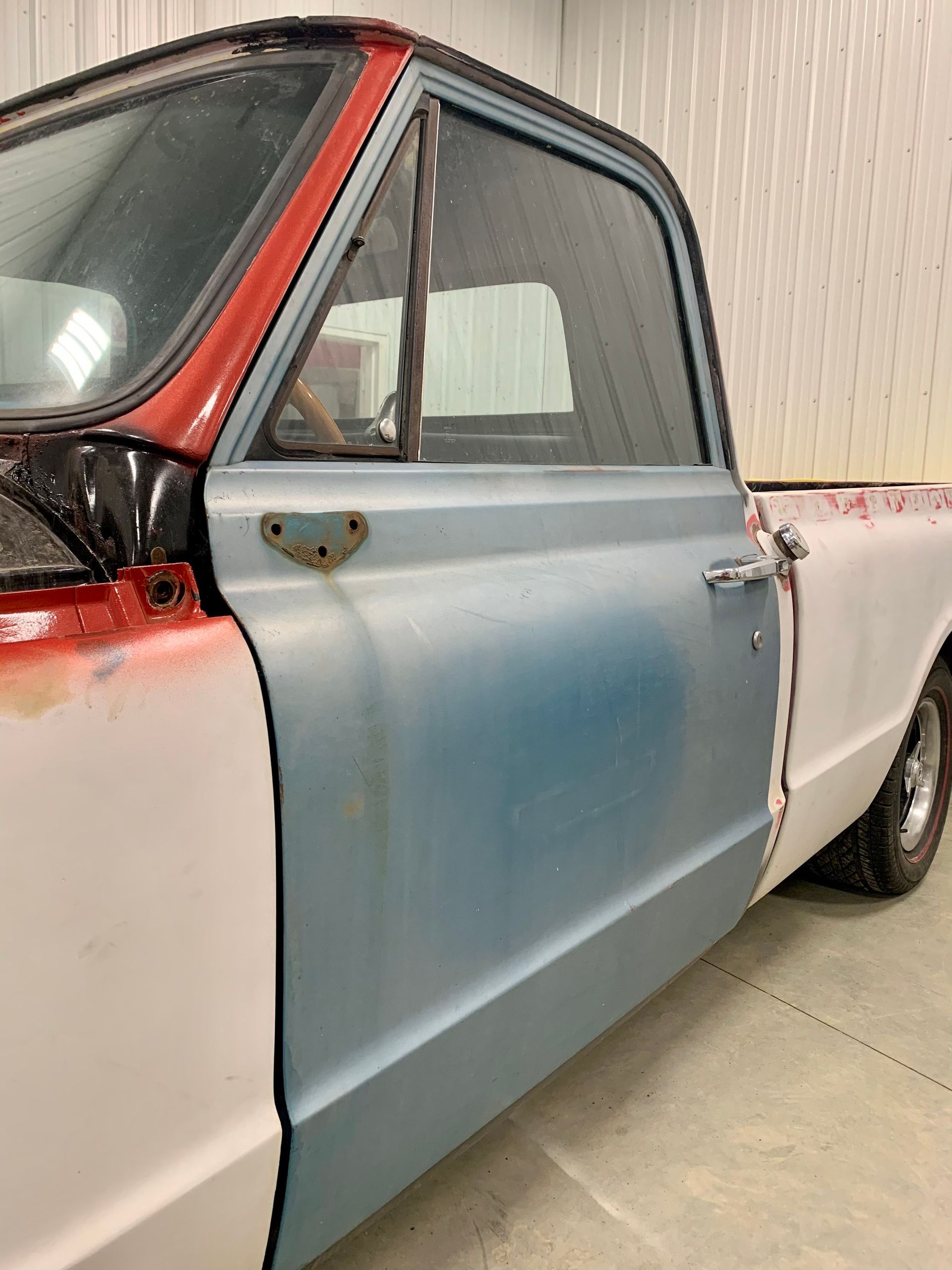 A blue and red truck is sitting in a garage.