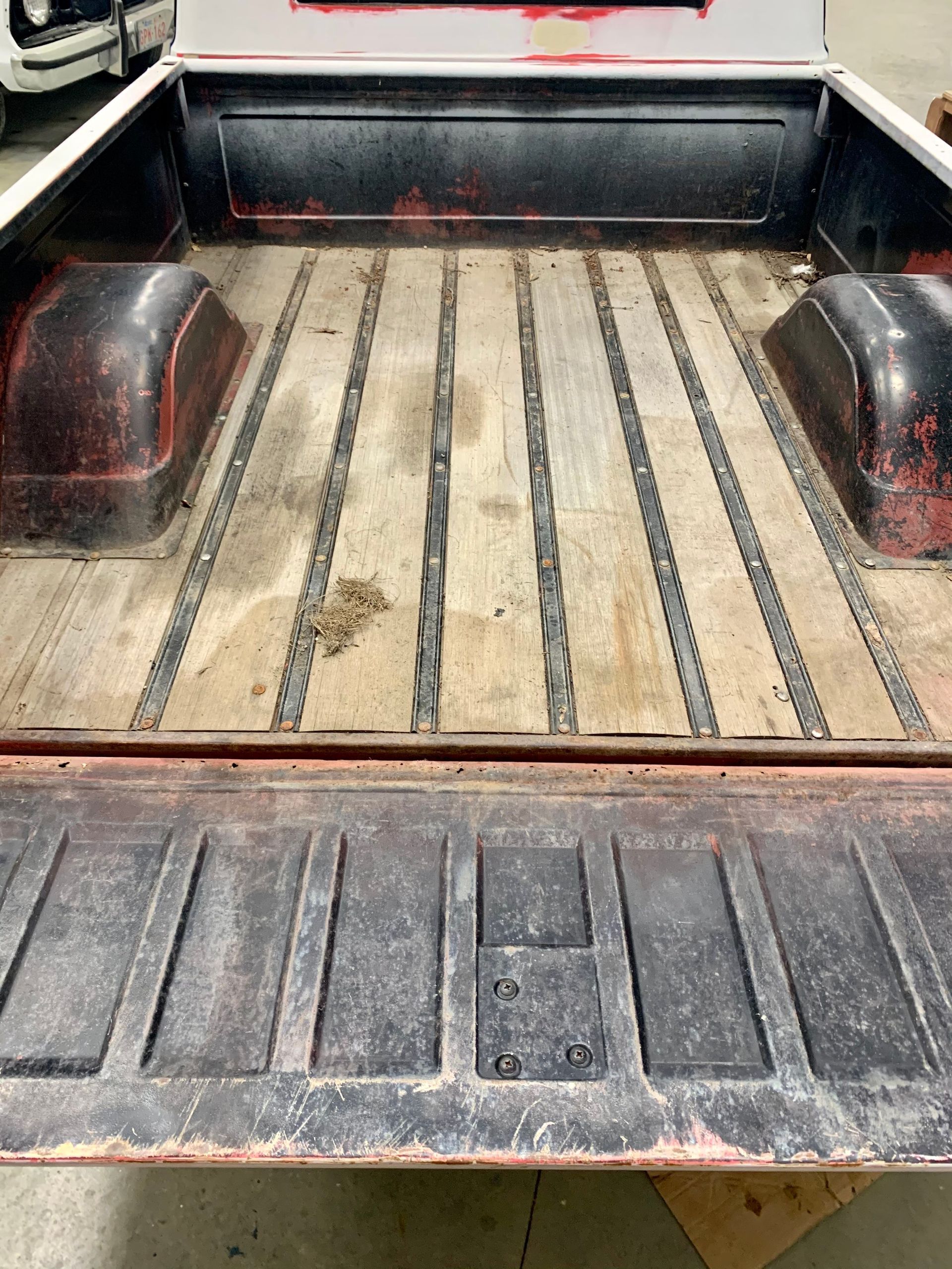 The back of a truck with a wooden bed.