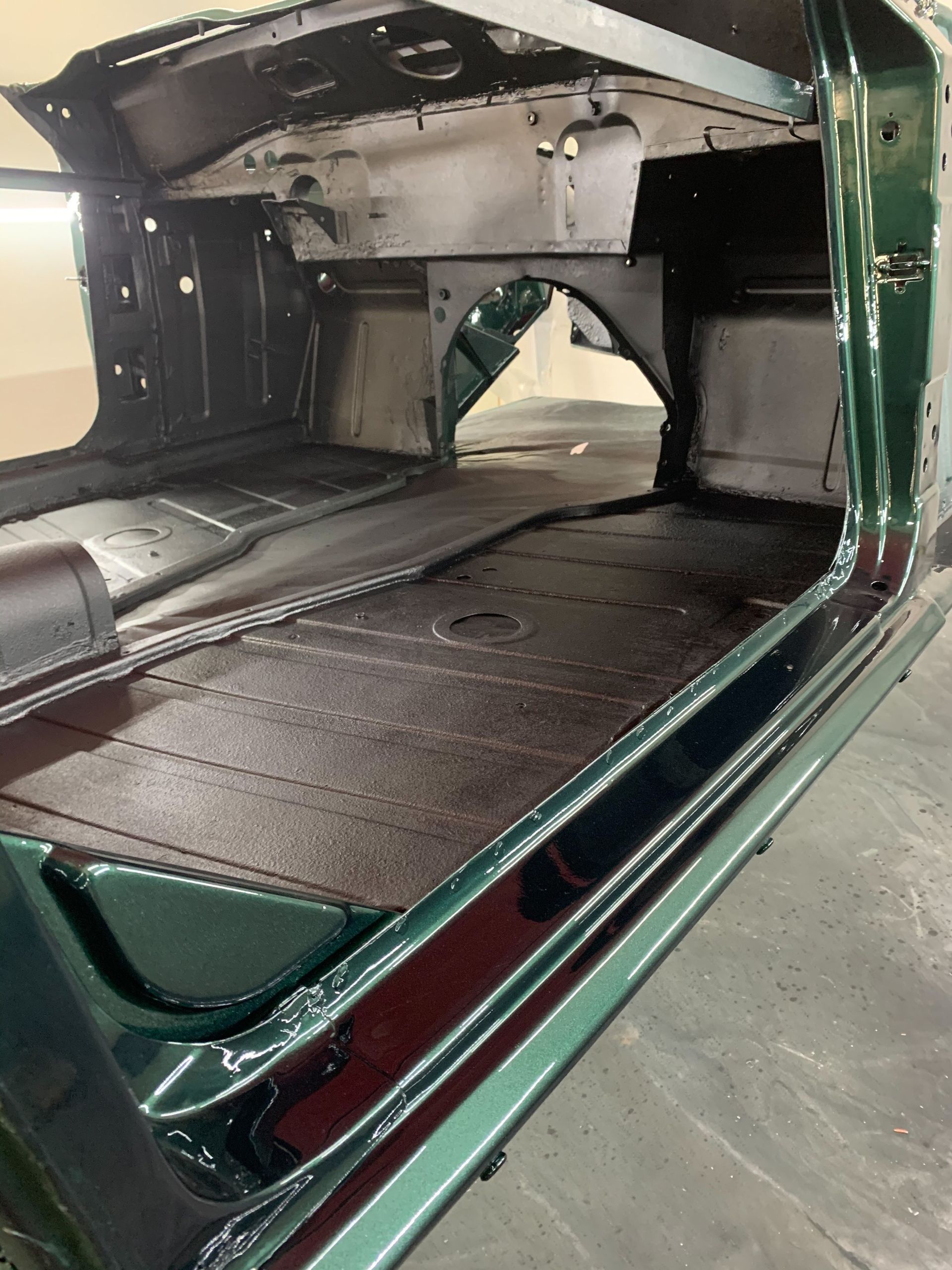 The inside of a green car with the door open.