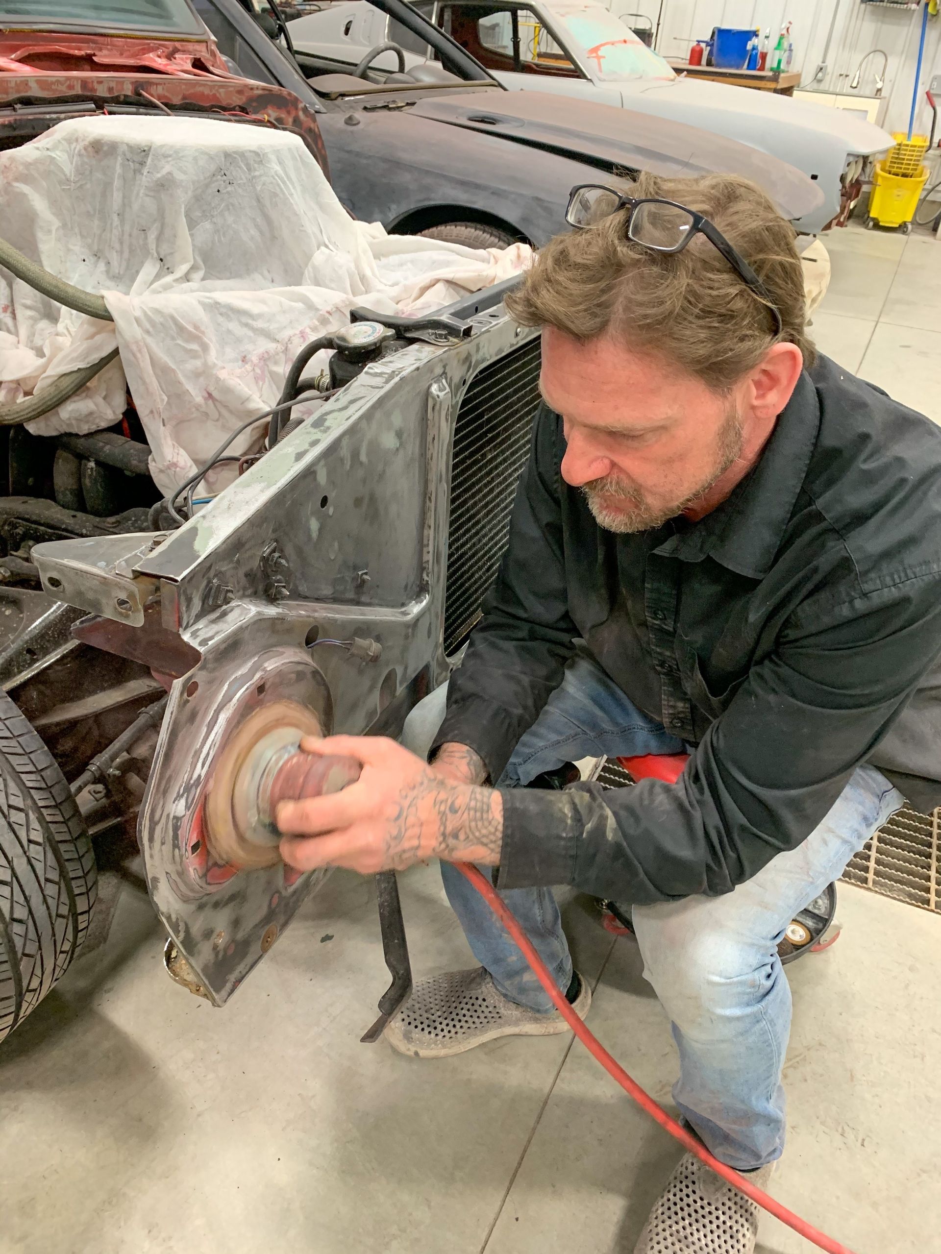 A man is working on a car in a garage.