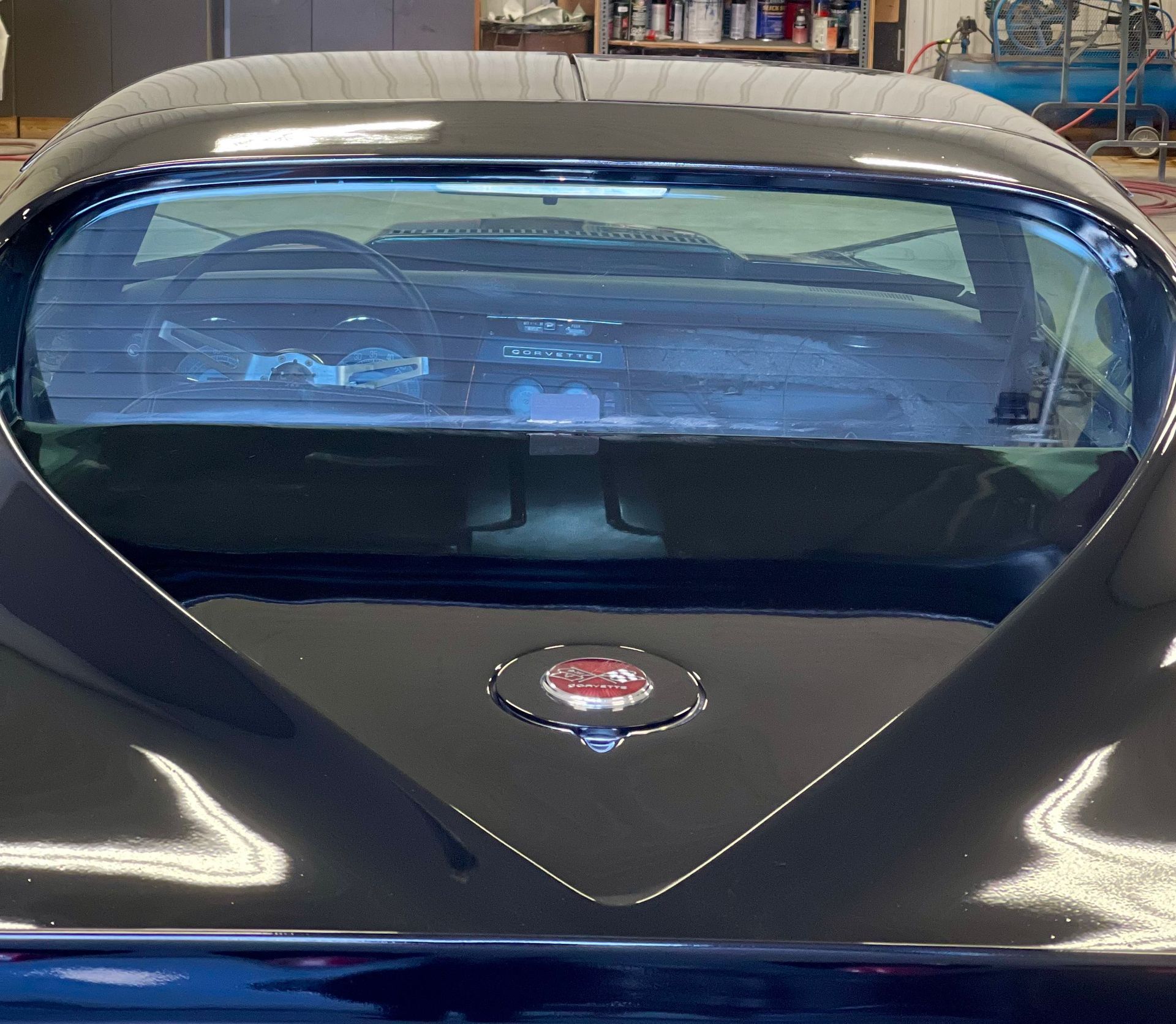The back of a black car with a heart shaped windshield