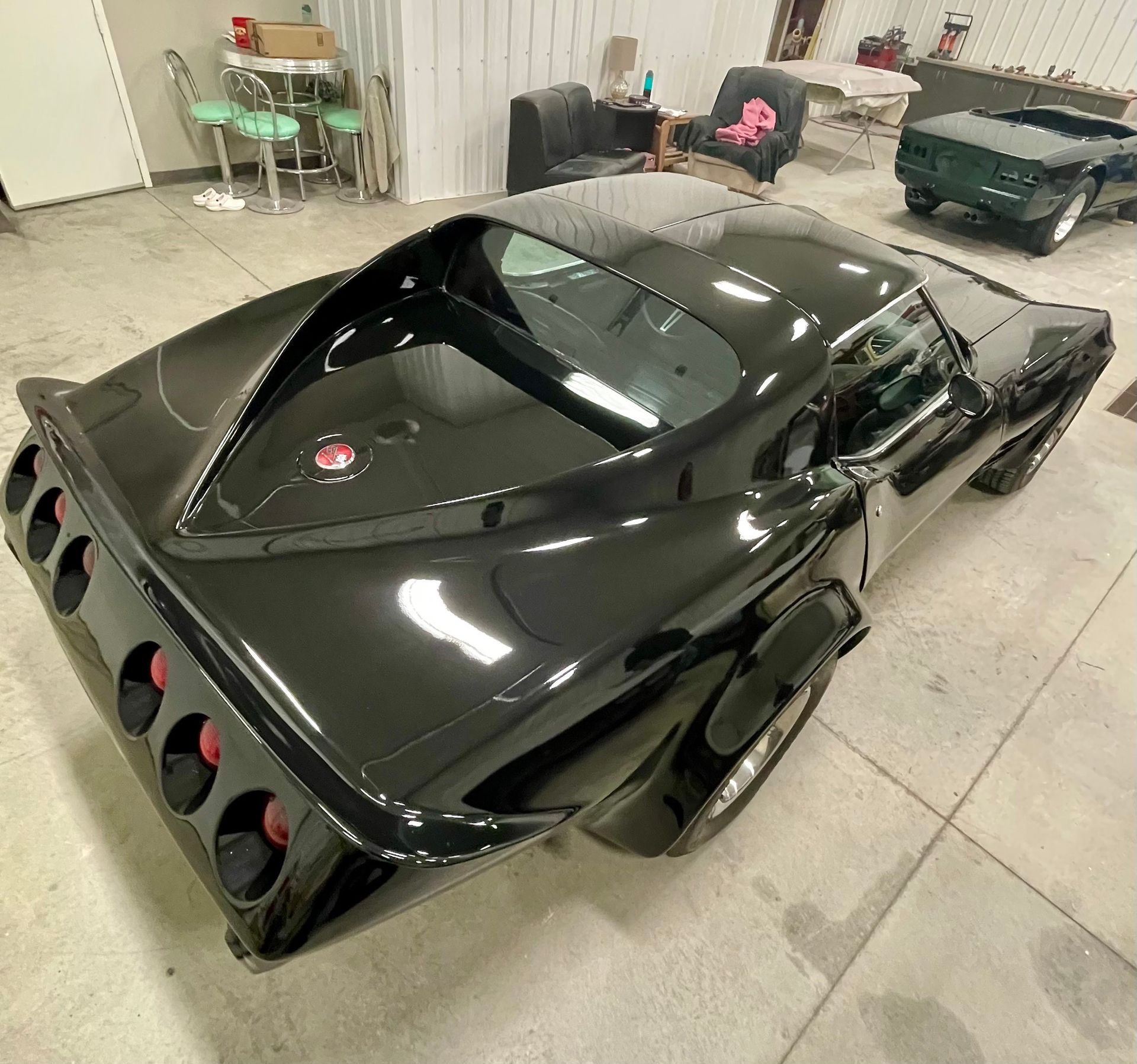 A black corvette is parked in a garage.