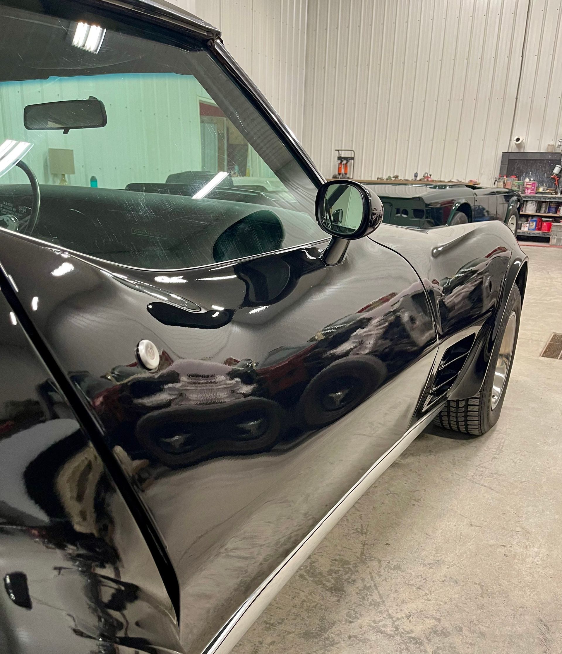 A black car is parked in a garage.