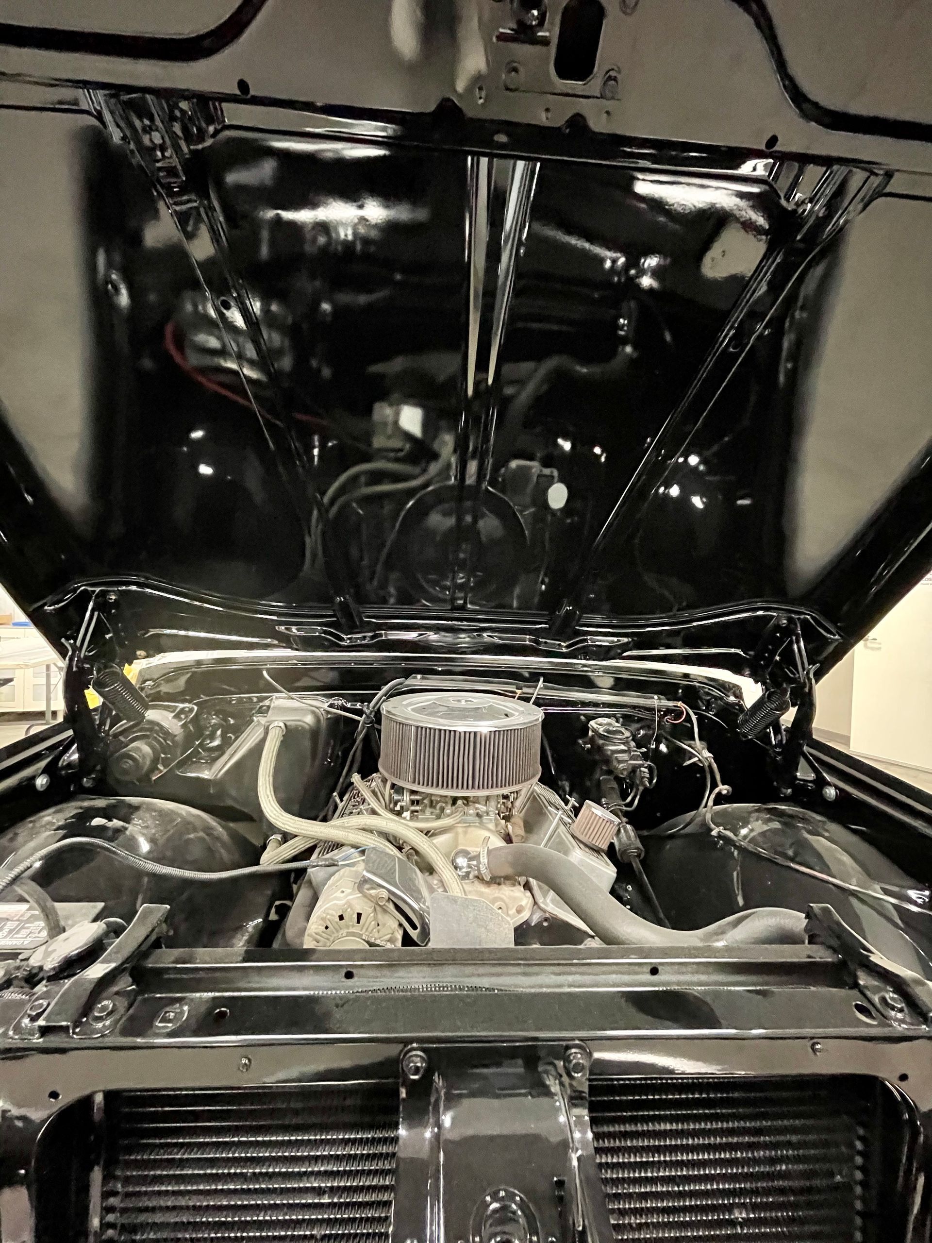 A close up of a car engine with the hood open