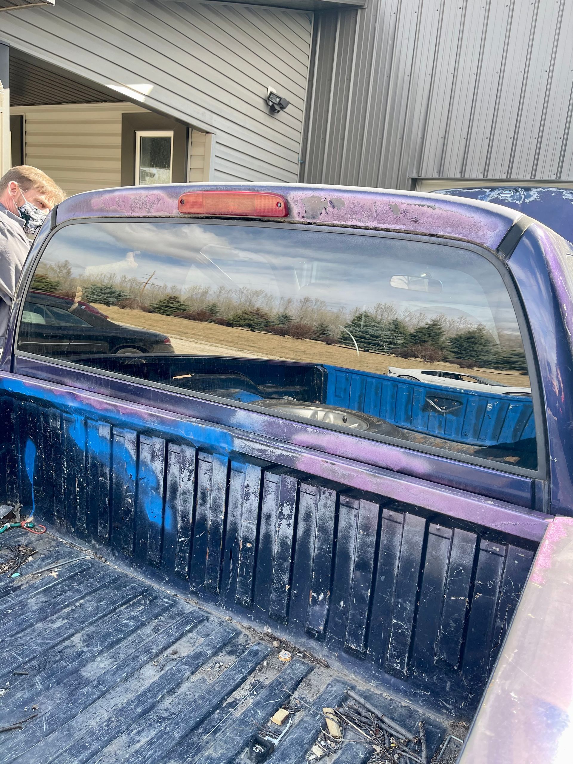 A purple truck is parked in front of a house.
