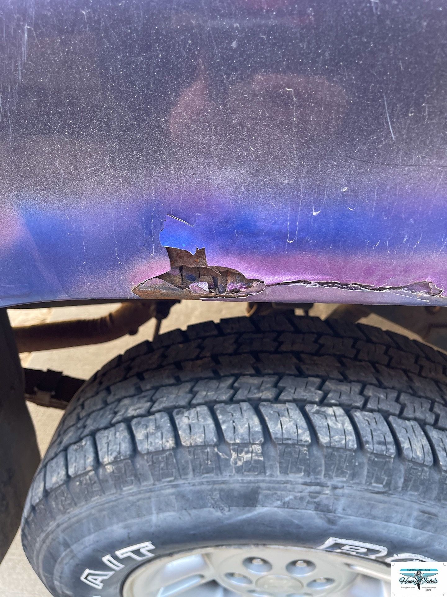 A close up of a tire on a car with a hole in it.