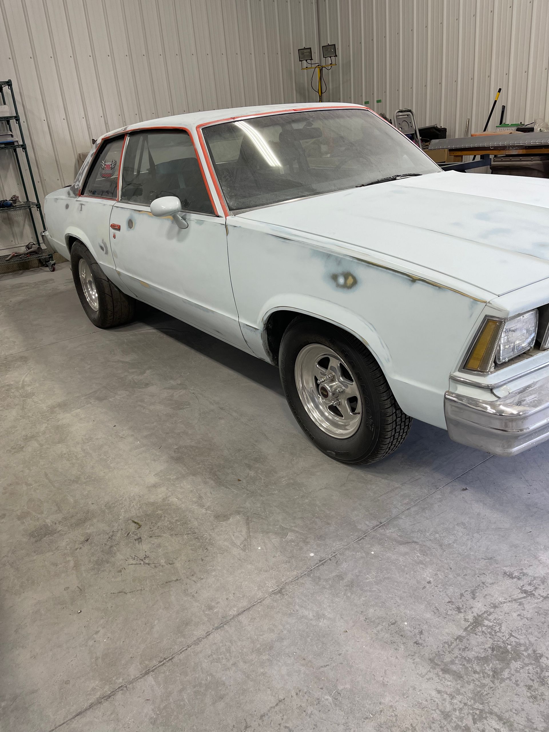 A white car is parked in a garage.