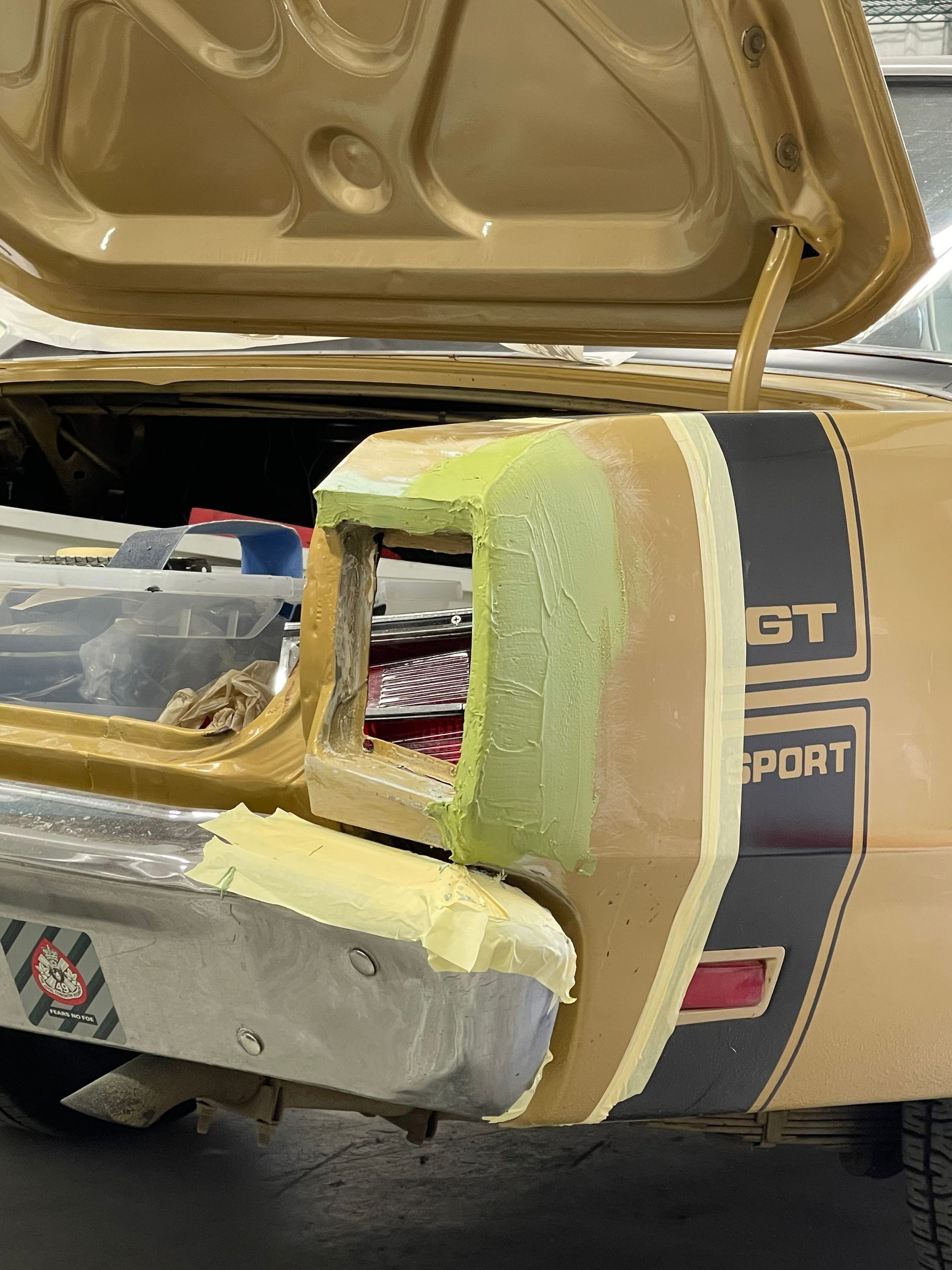 A car with the hood open is being repaired.