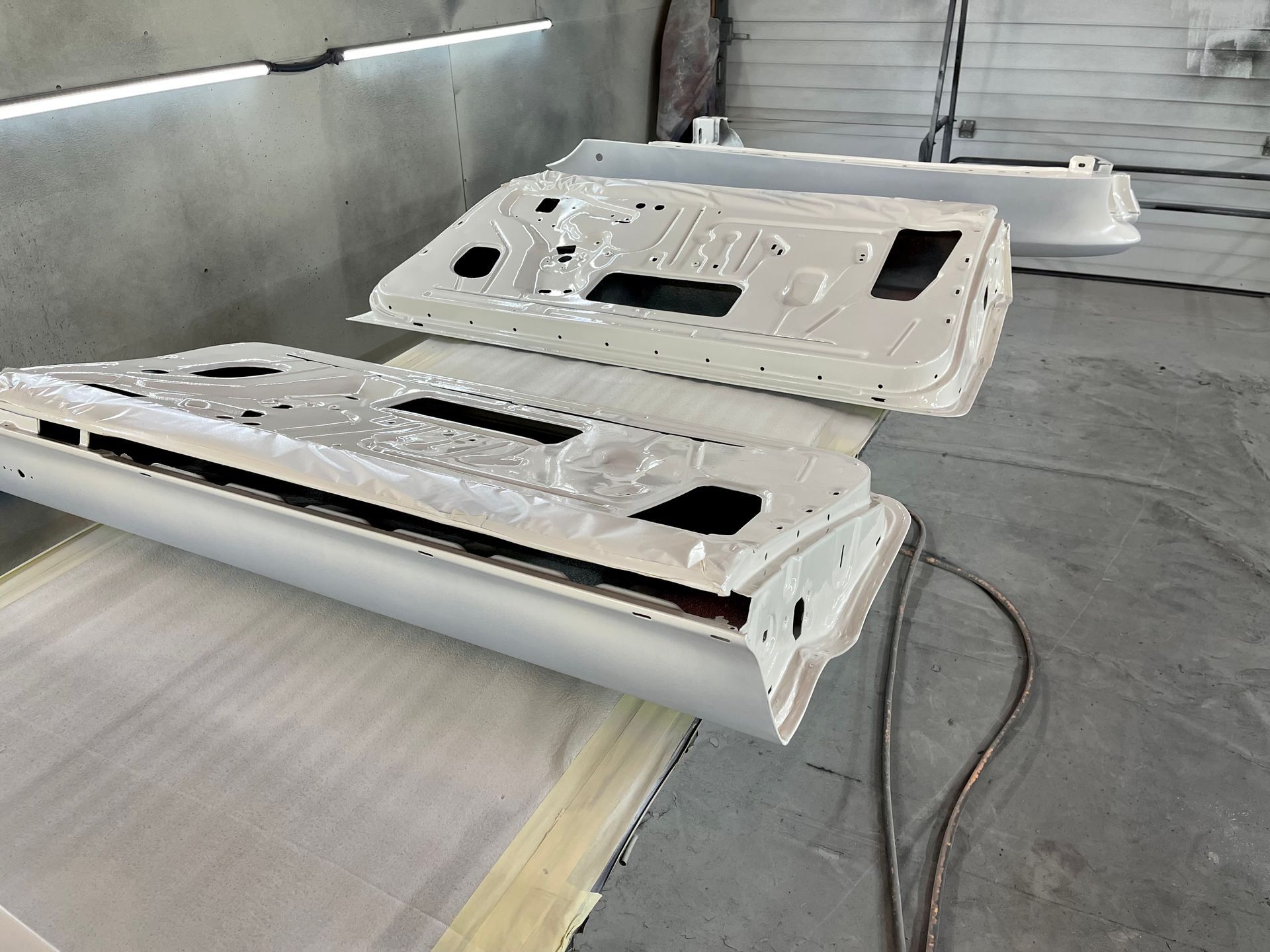 Two white doors are sitting on a table in a garage.